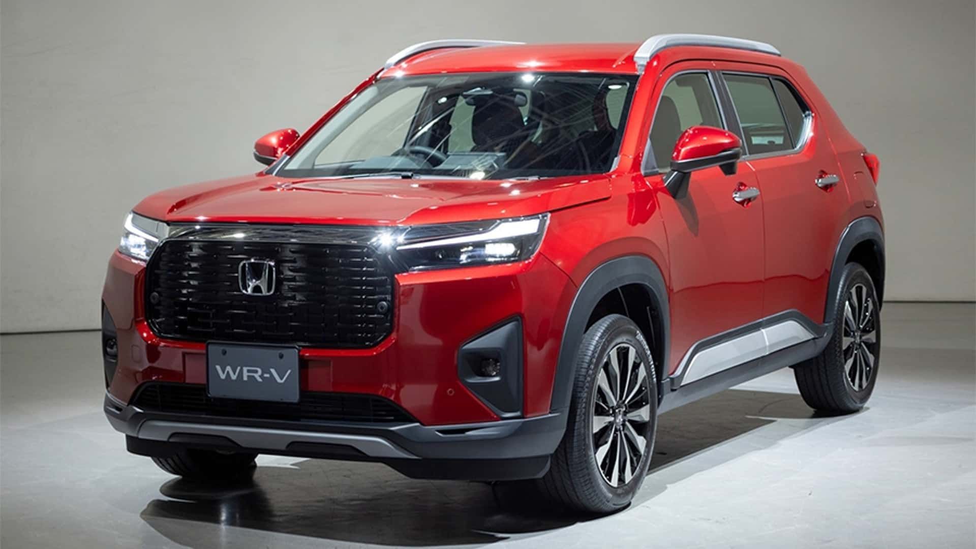 SUV compacto vermelho brilhante, vista frontal em três quartos sobre um fundo de estúdio.