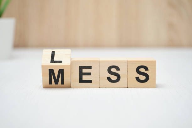 The word mess is written on wooden blocks on a table.