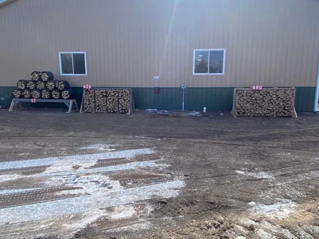 A building with a lot of logs in front of it