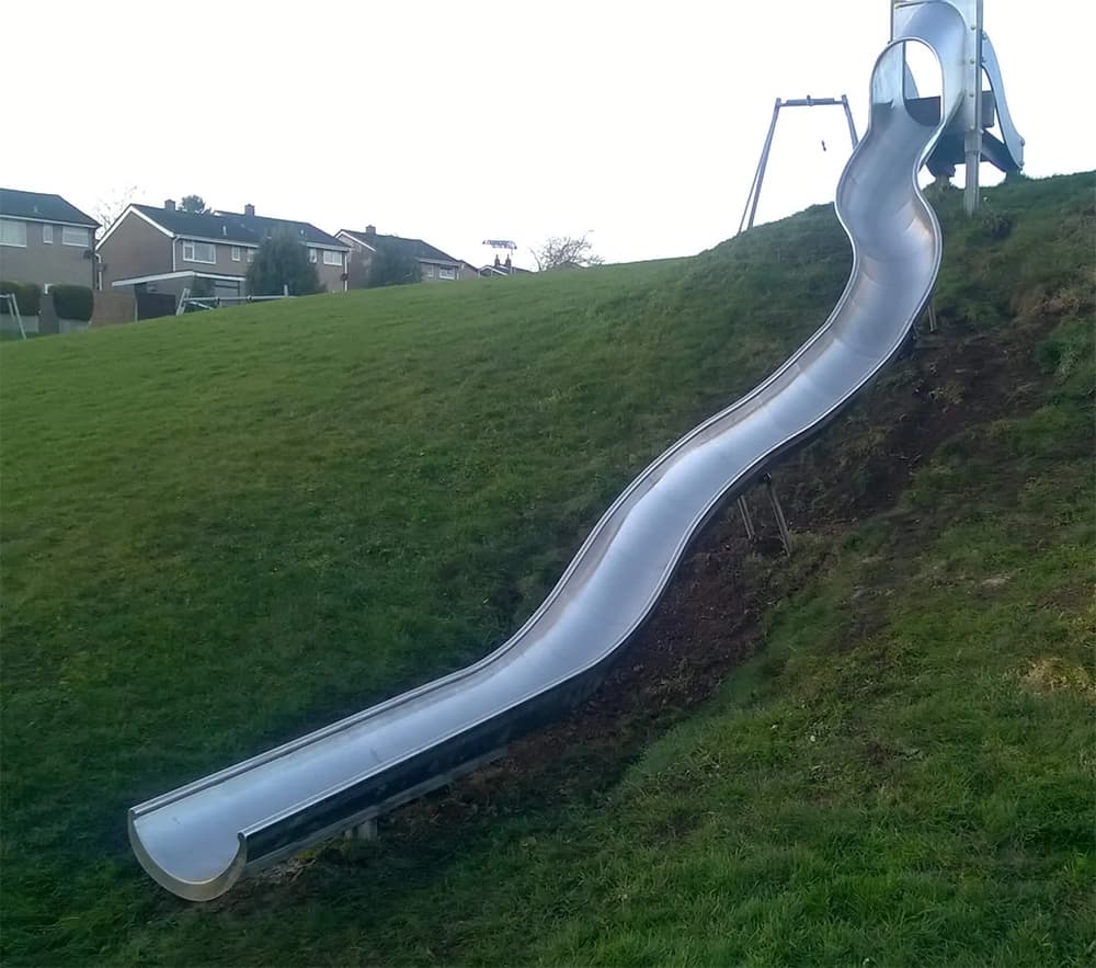 Curved Playground Slide in Grass Bank