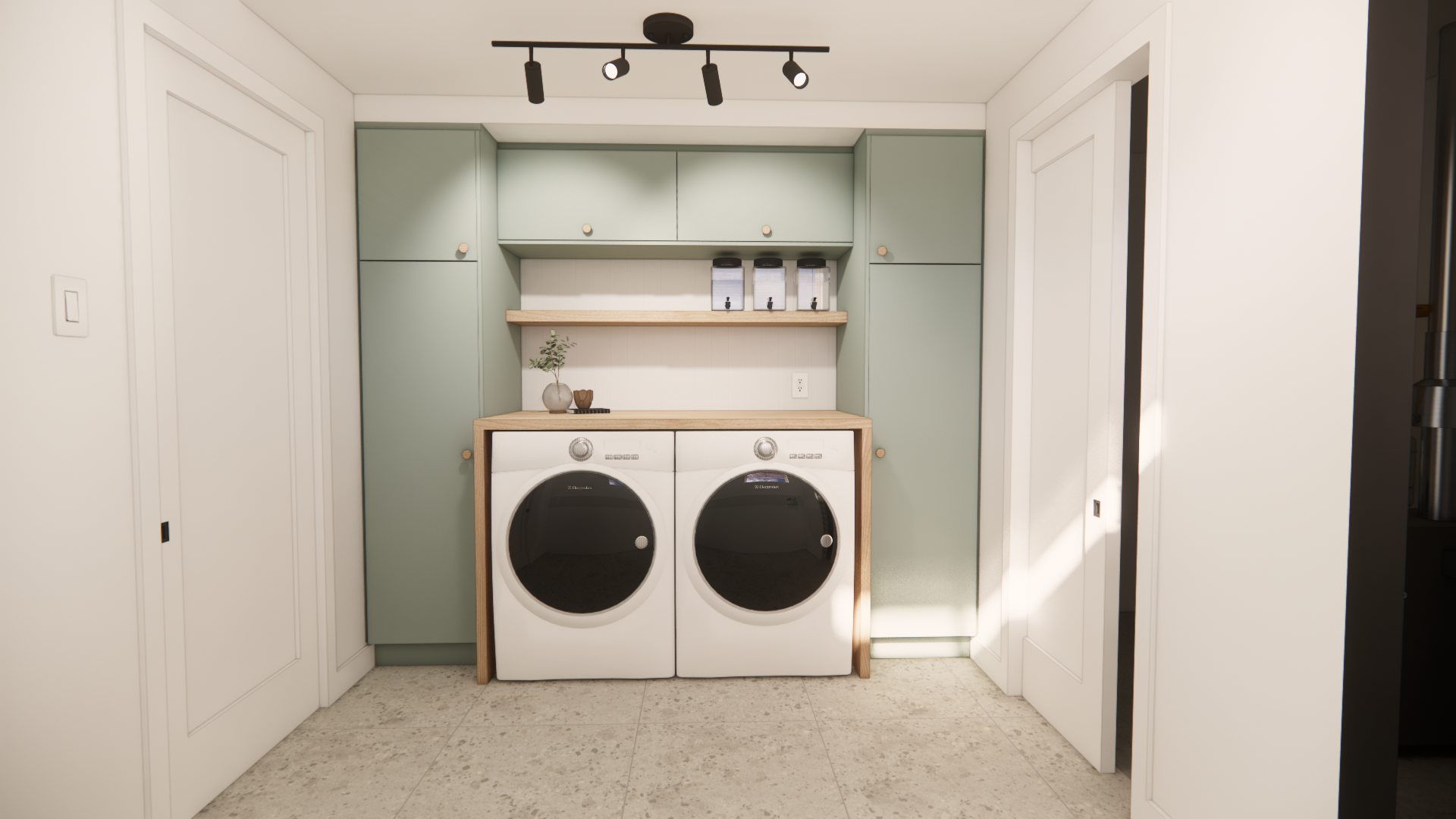 Buanderie avec placards verts, lave-linge/sèche-linge blanc et éclairage sur rail au plafond.