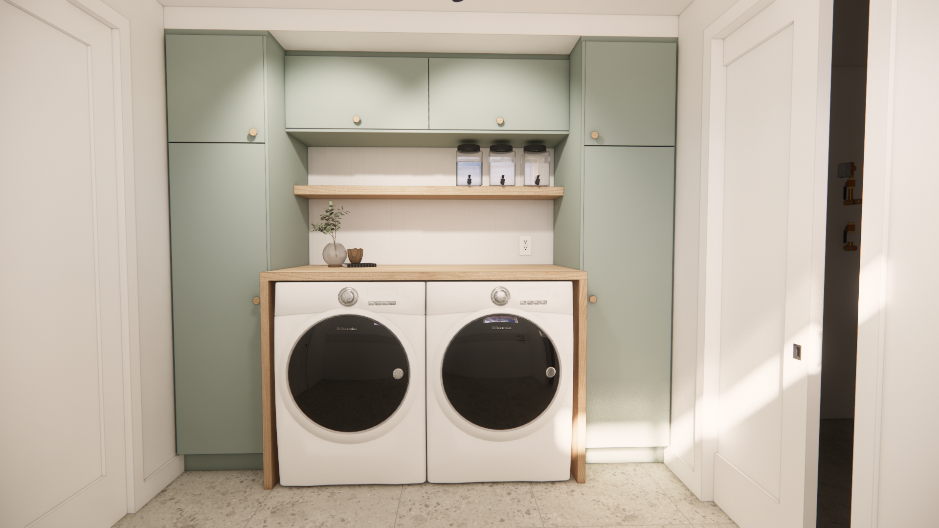 Buanderie avec placards vert sauge, lave-linge/sèche-linge et éléments en bois. Des portes blanches bordent la pièce.