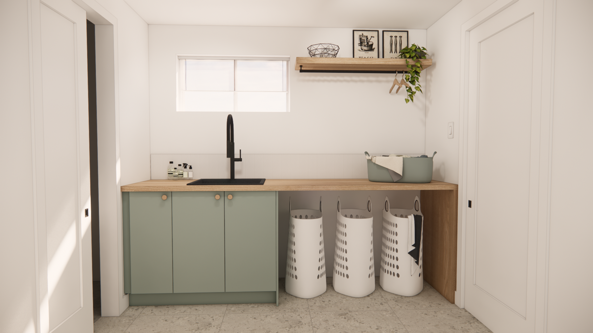 Buanderie avec placards vert sauge, plan de travail en bois, robinet noir et sacs à linge blancs.