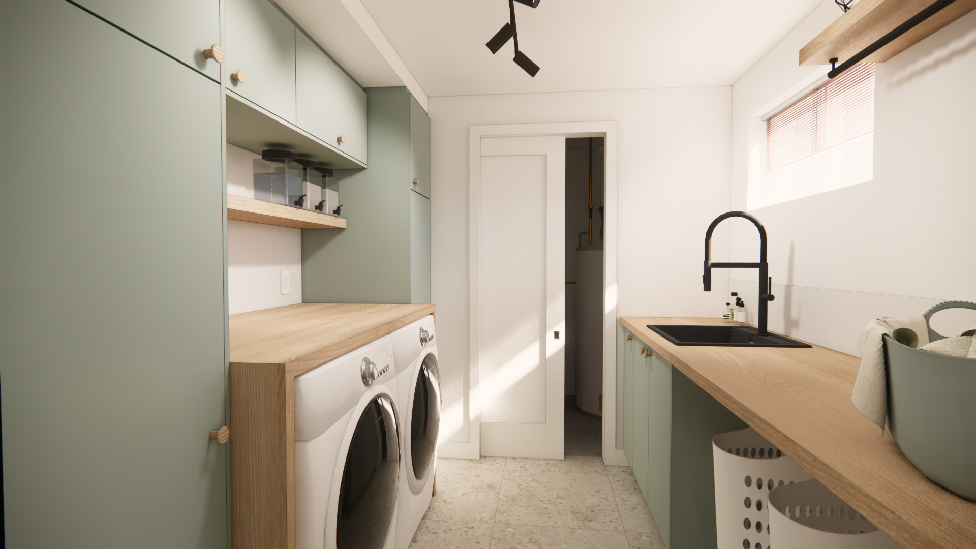 Buanderie avec placards vert sauge, plans de travail en bois, lave-linge/sèche-linge et robinet noir.