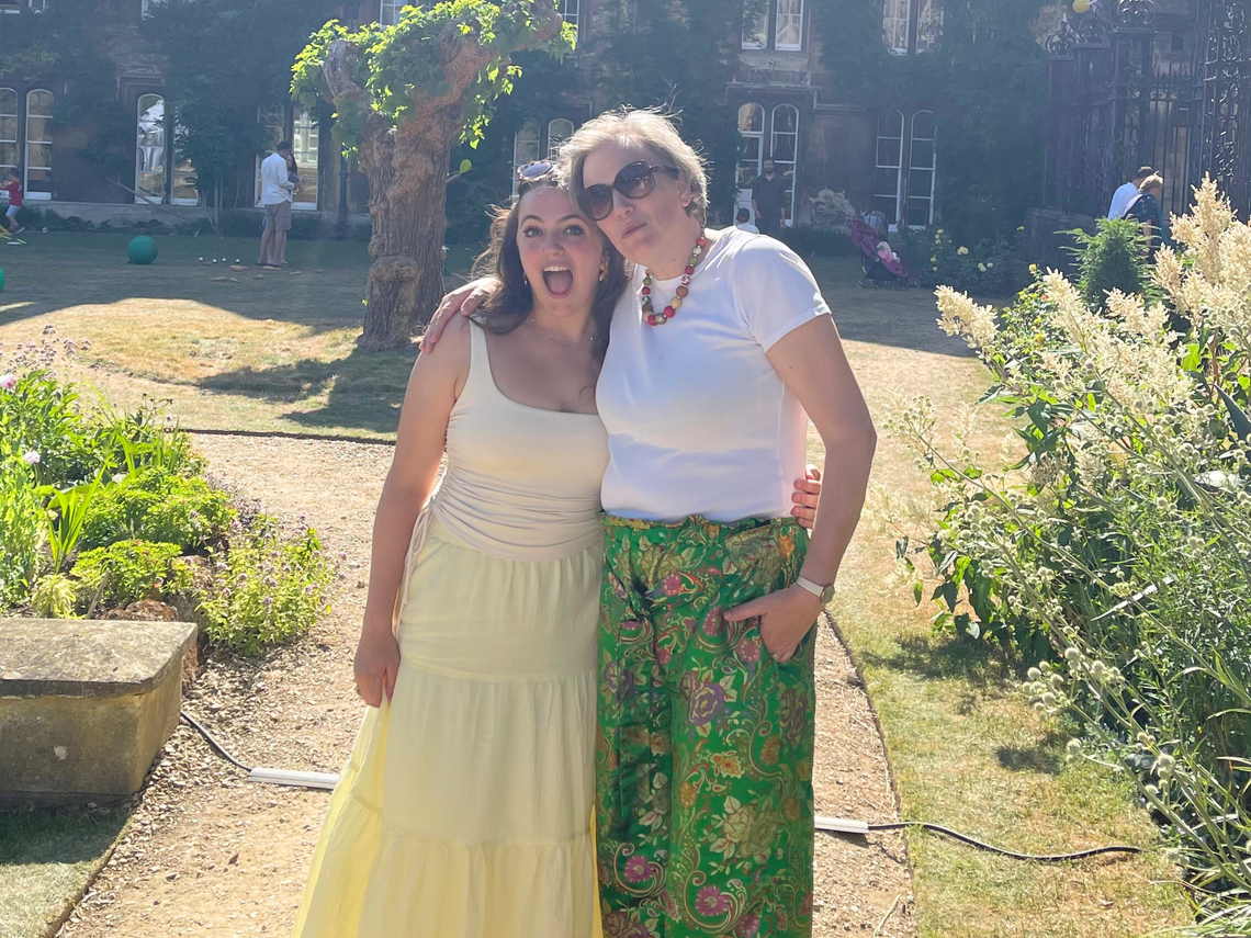 Lisa Walters and her daughter in a garden. Lisa is wearing a pair of the Grace Trousers that she made using the pattern, sold in the shop on this website