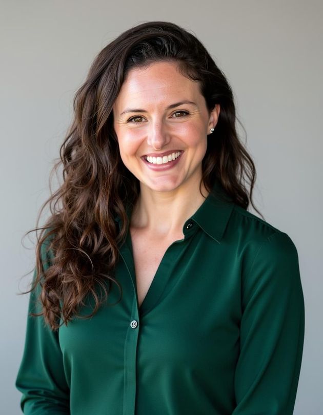 A woman in a green shirt is smiling for the camera.