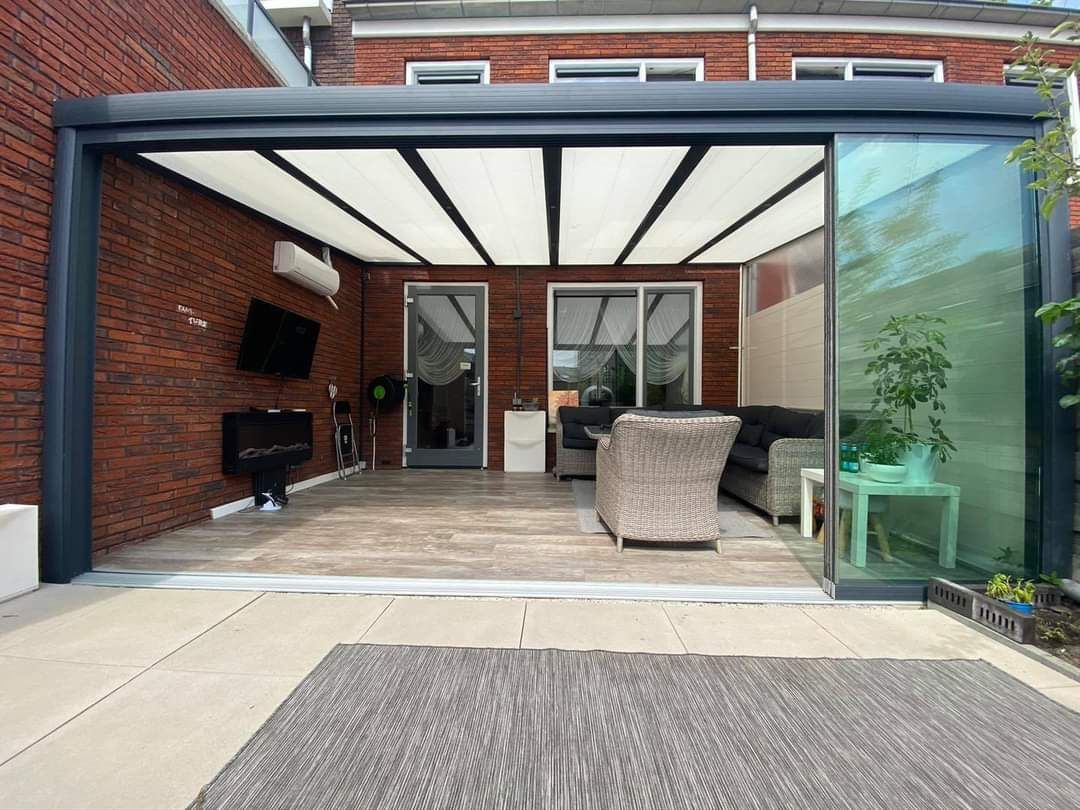 Een patio met een glazen schuifdeur die naar een woonkamer leidt.