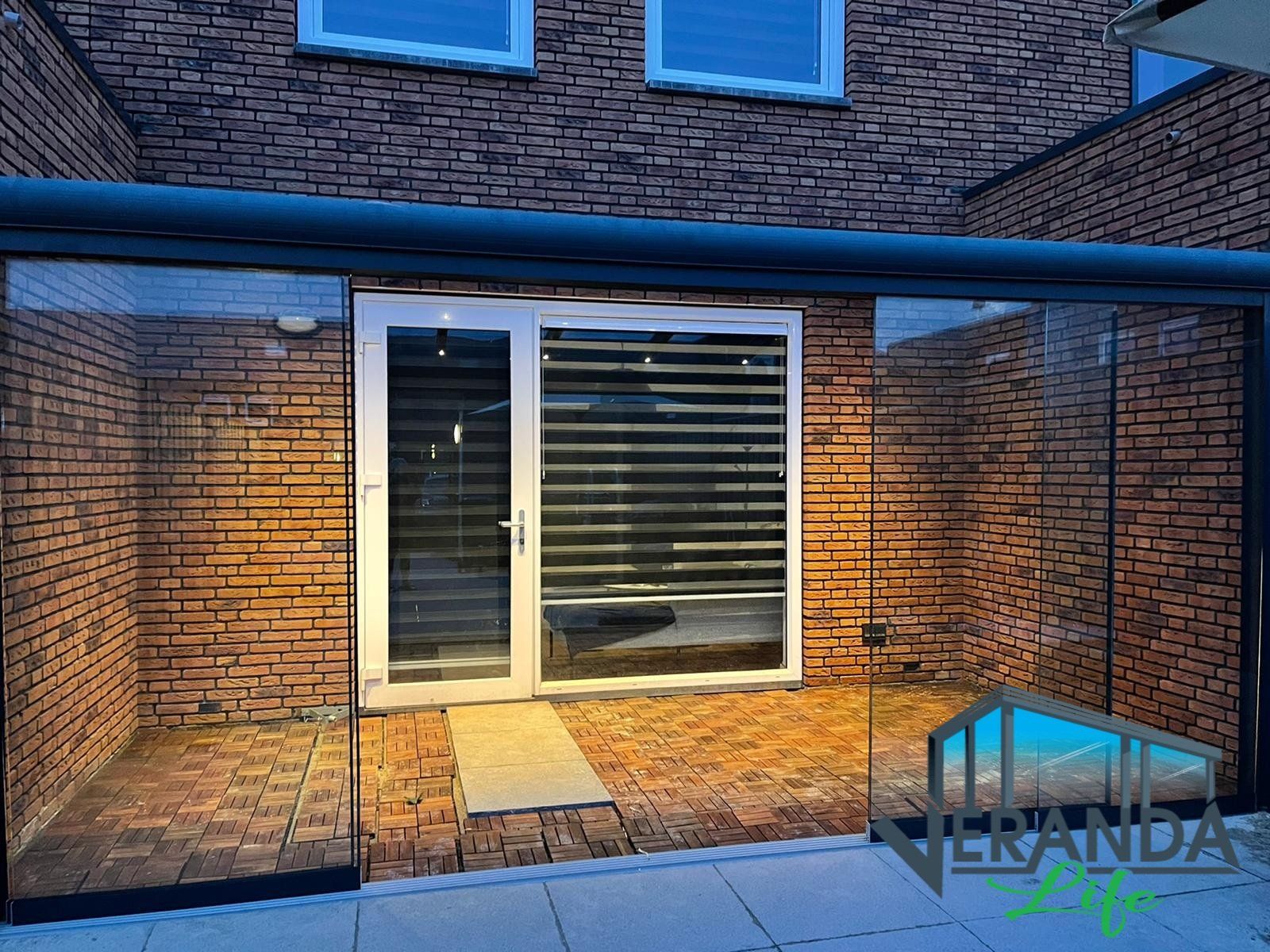 Een bakstenen gebouw met een patio en een glazen schuifdeur