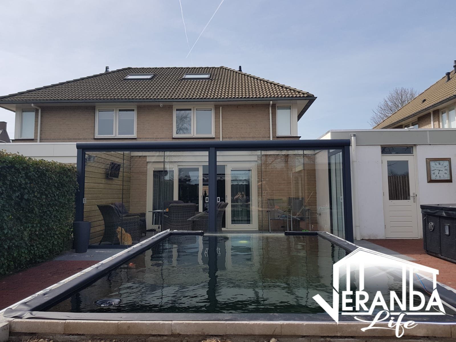 Een groot zwembad bevindt zich in de achtertuin van een huis.