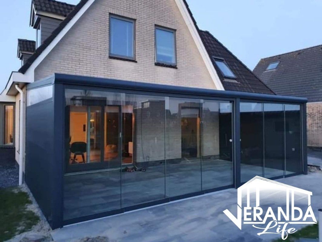 Een foto van een huis met een veranda ervoor