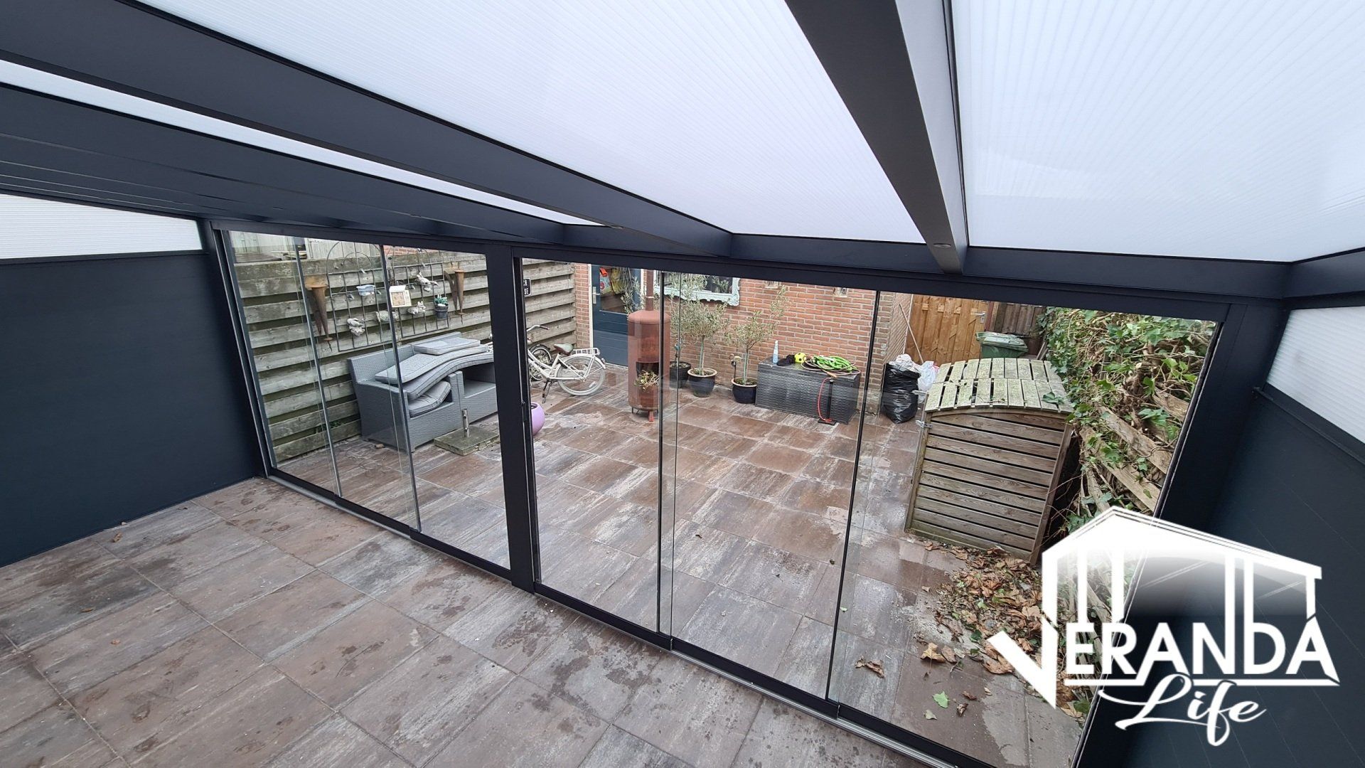 Een kamer met veel ramen en een bord waarop 'verandaleven' staat