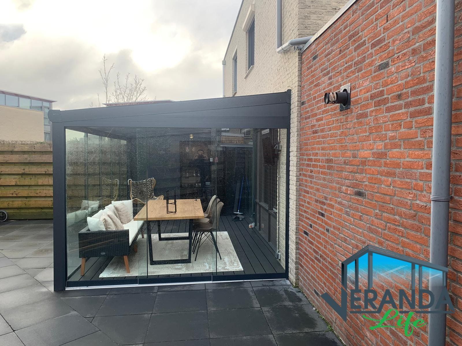 Een patio met een tafel en stoelen voor een bakstenen gebouw.