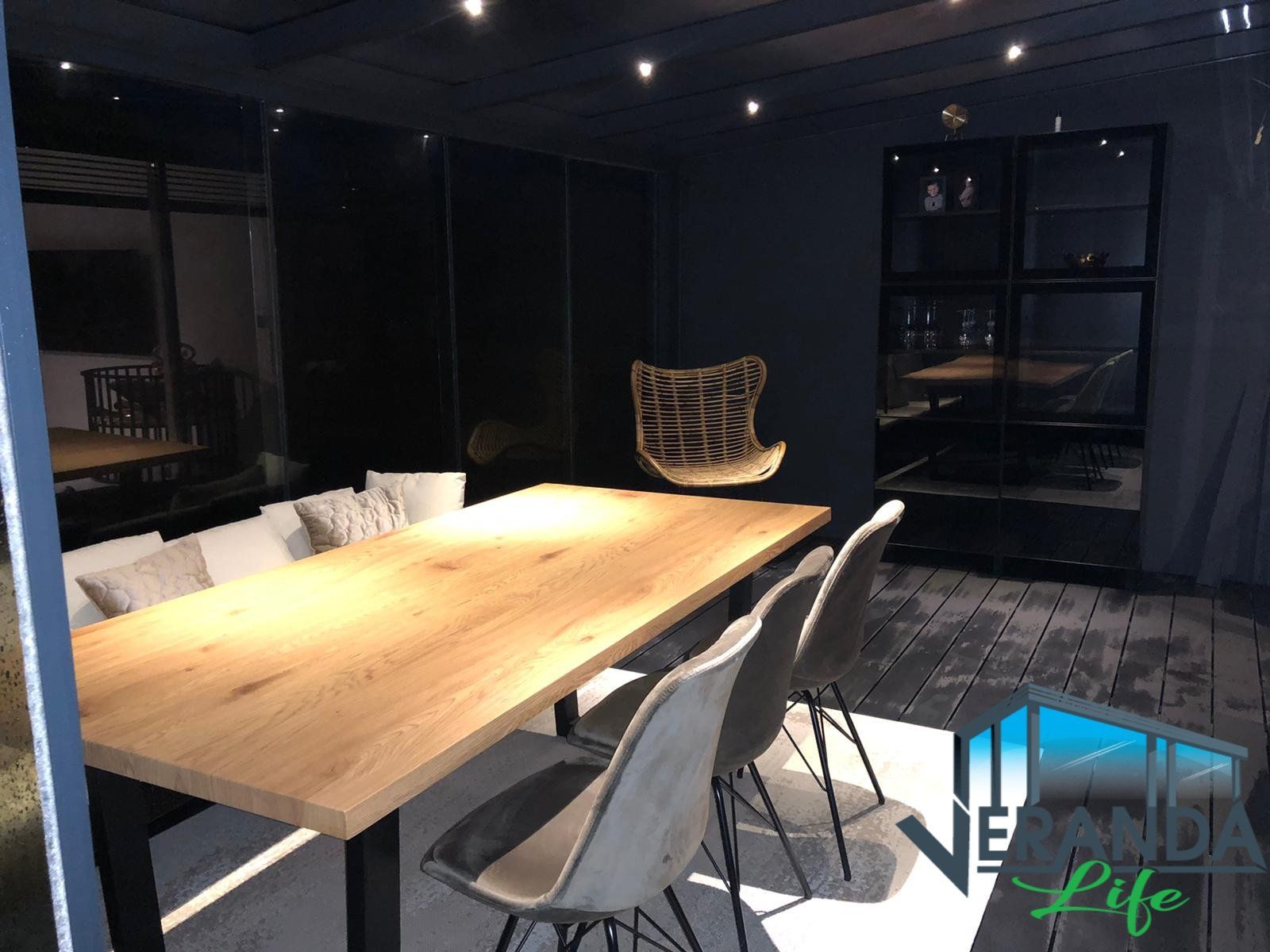 Een houten tafel en stoelen in een donkere kamer