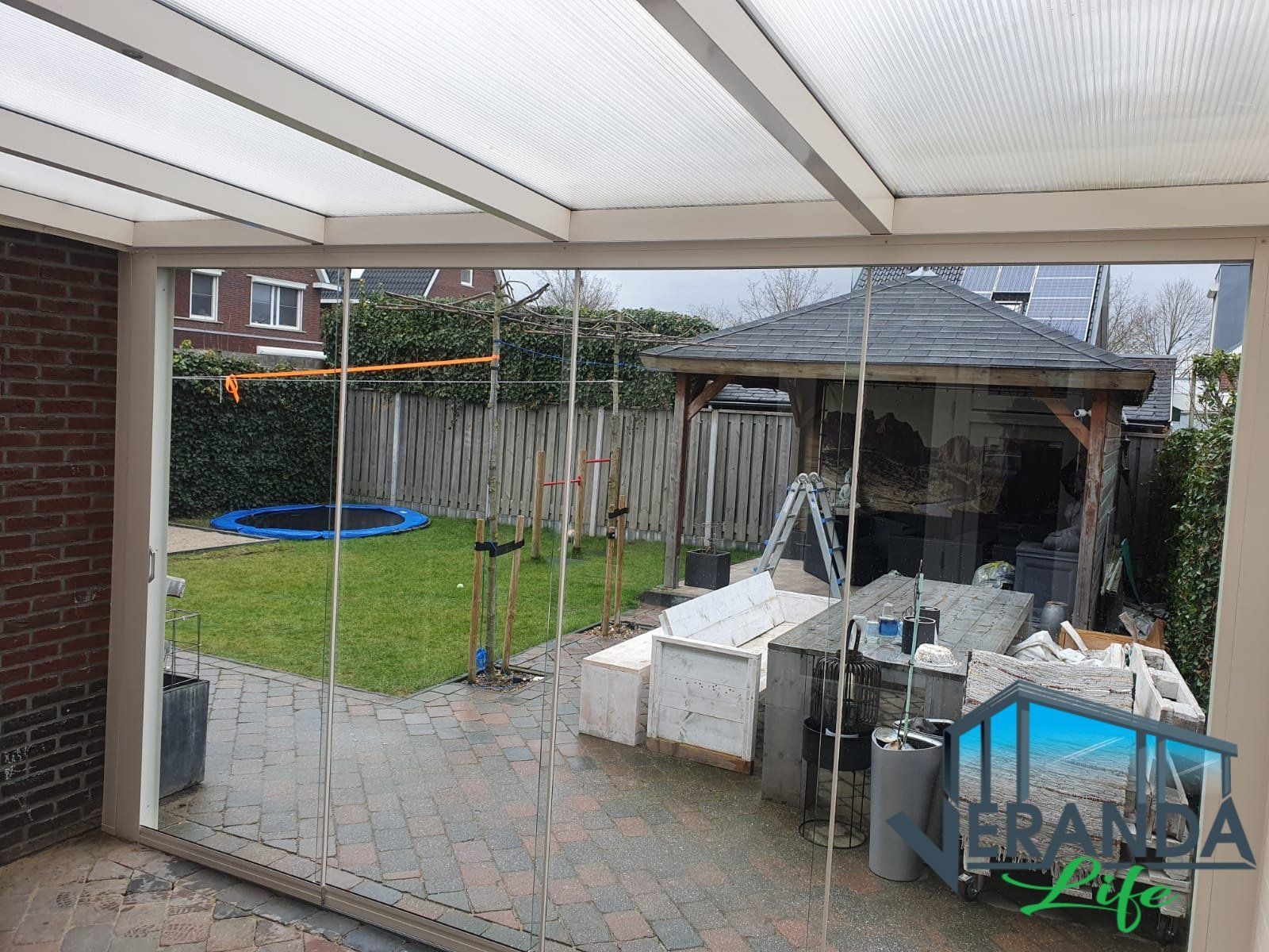 Een zicht op een achtertuin door een glazen schuifdeur