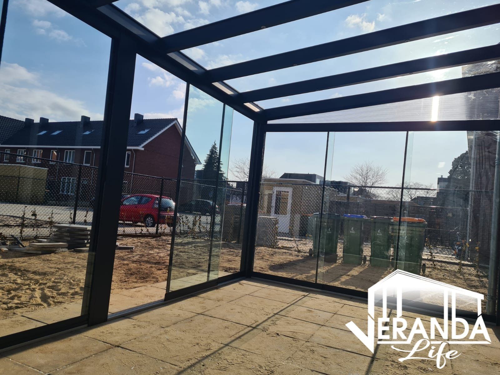 Een kamer met veel ramen en een glazen dak.