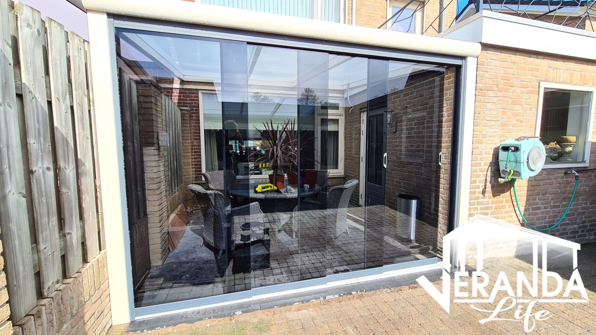 Een bakstenen gebouw met een glazen schuifdeur die naar een patio leidt.