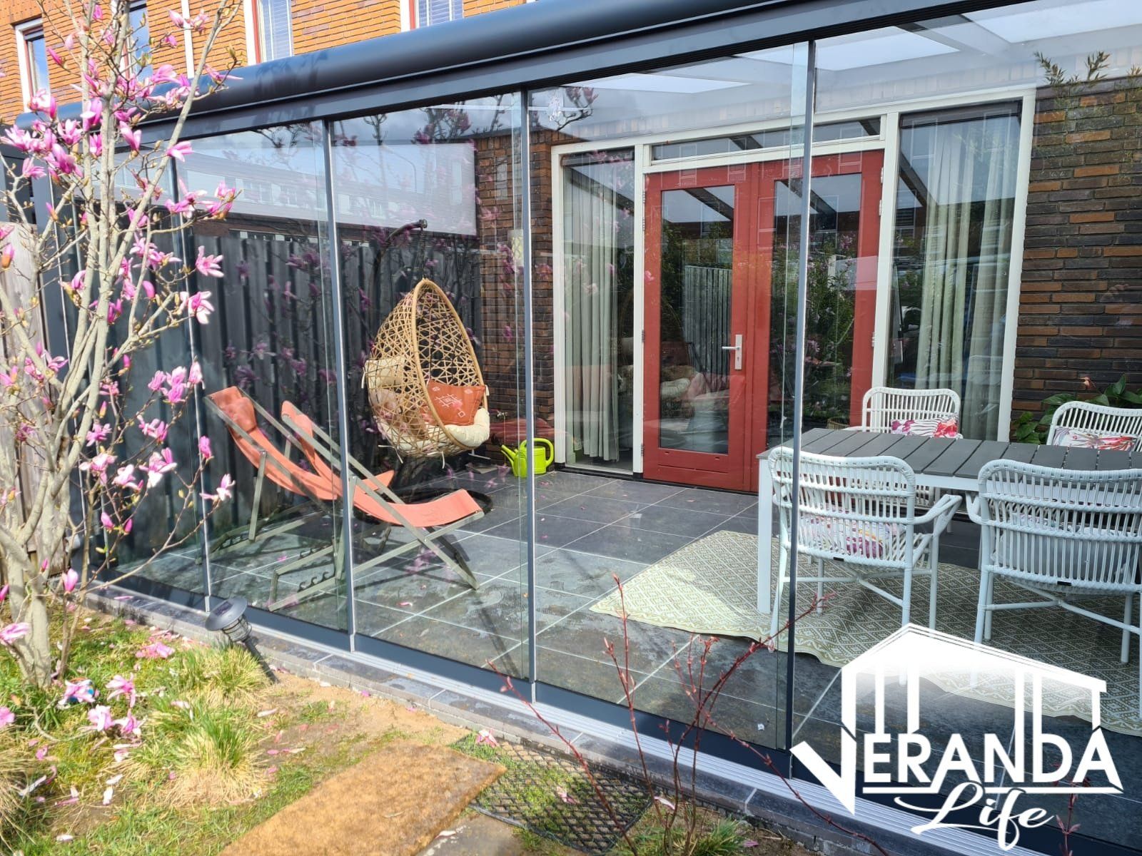 Een patio met een tafel en stoelen voor een huis.