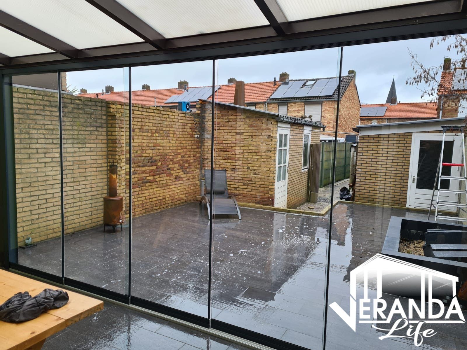 Een kamer met glazen schuifdeuren die naar een patio leiden.