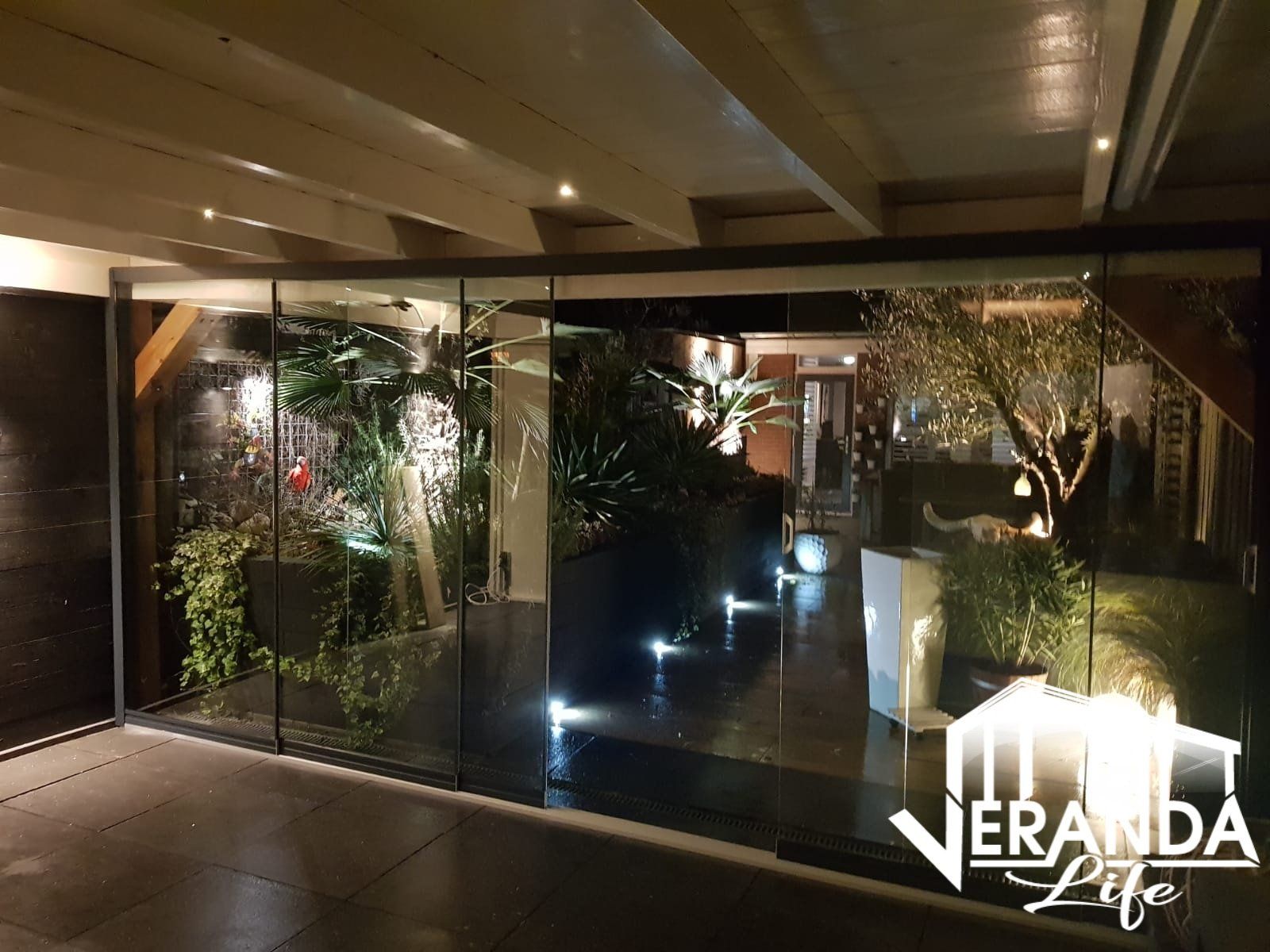 Een kamer met een glazen wand en een bord met verandaleven