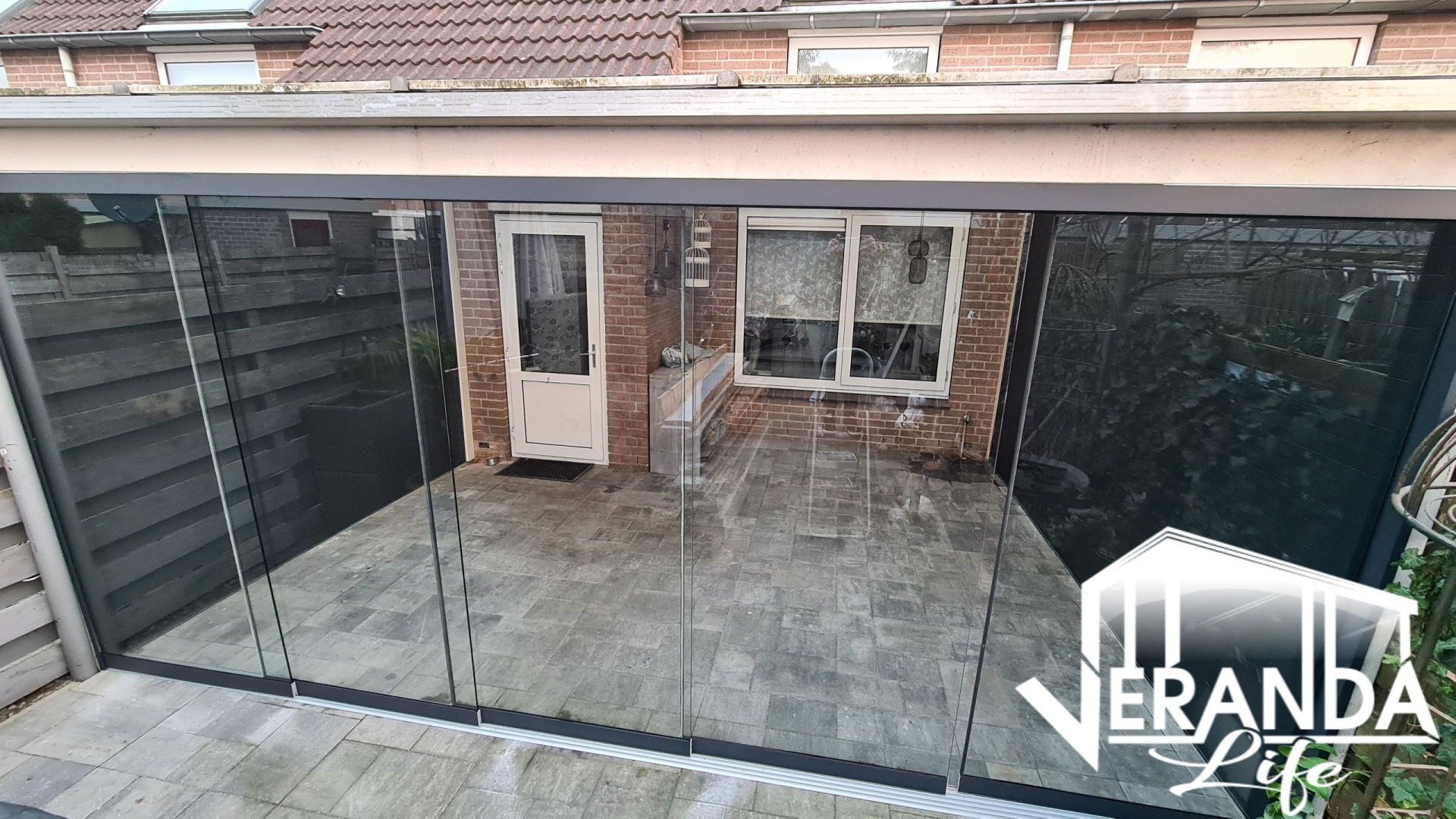 Een huis met een patio en een glazen schuifdeur.