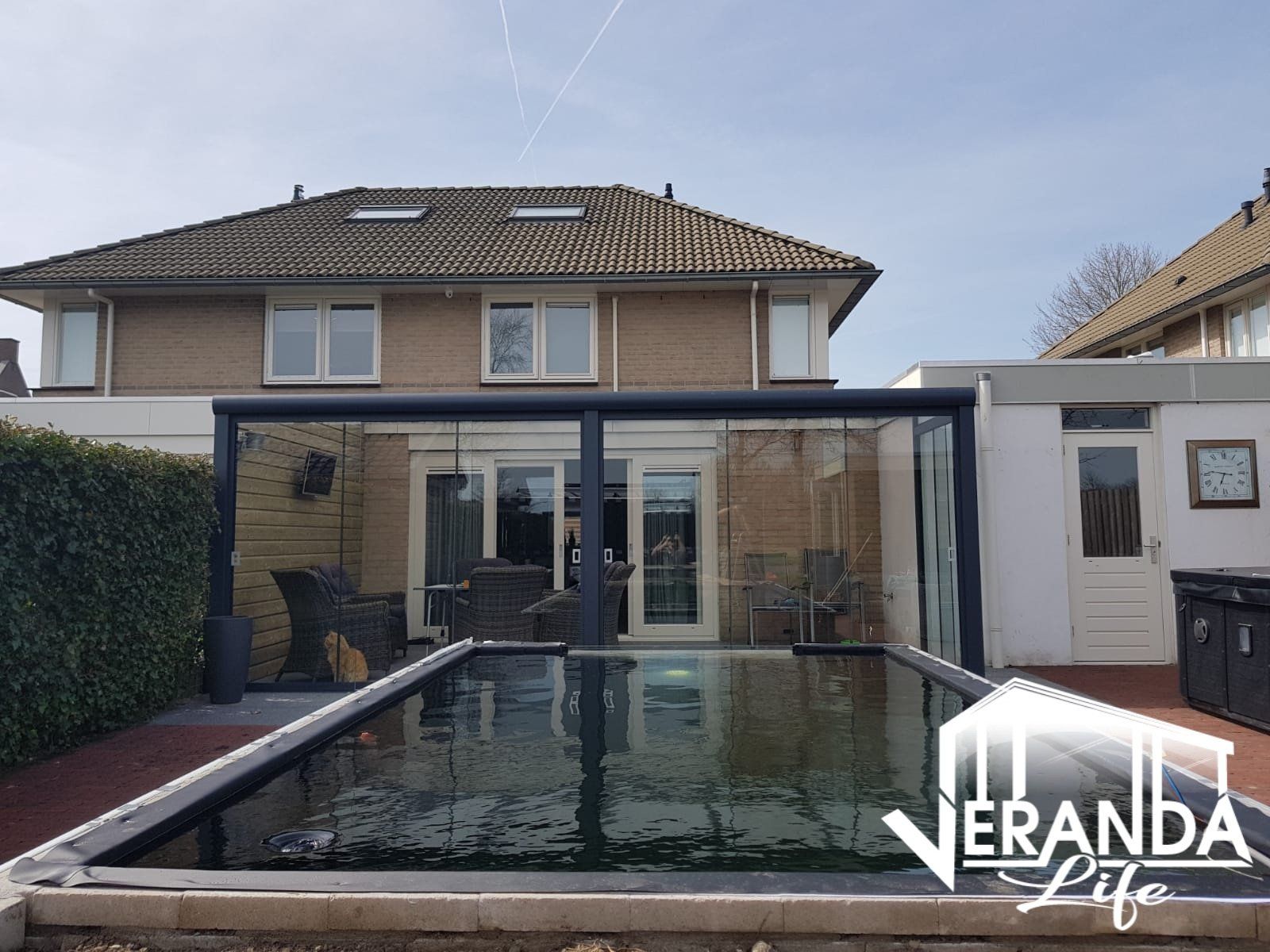 Een groot zwembad bevindt zich in de achtertuin van een huis.