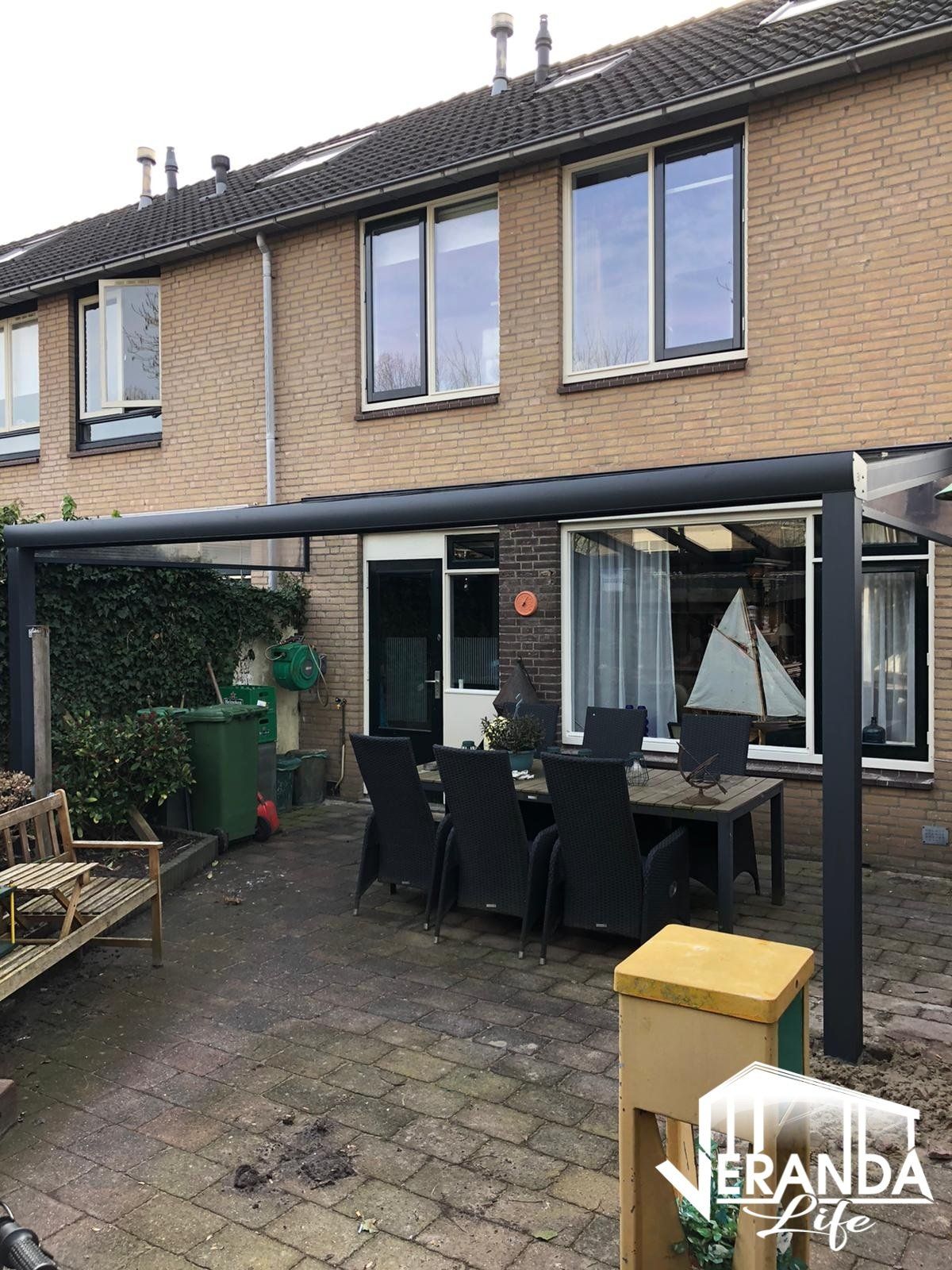 Een patio met een tafel en stoelen voor een huis.