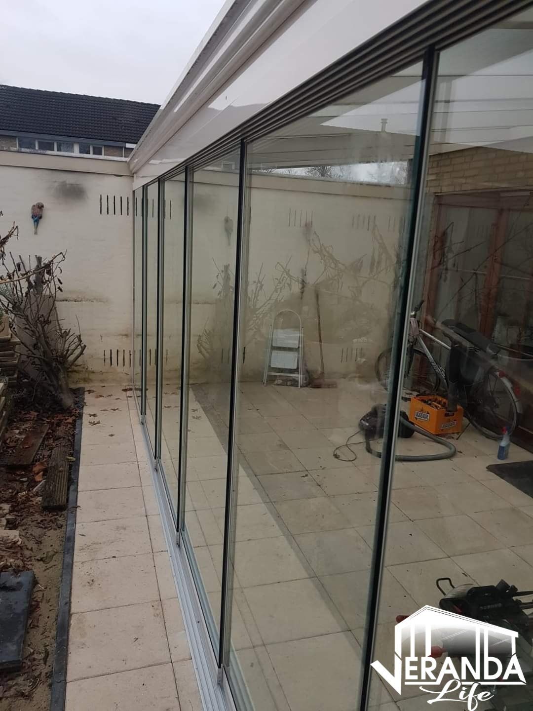 Een rij glazen schuifdeuren die naar een patio leiden.