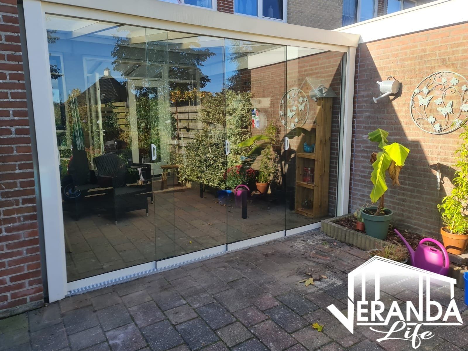 Een patio met een glazen schuifdeur en een bakstenen muur.