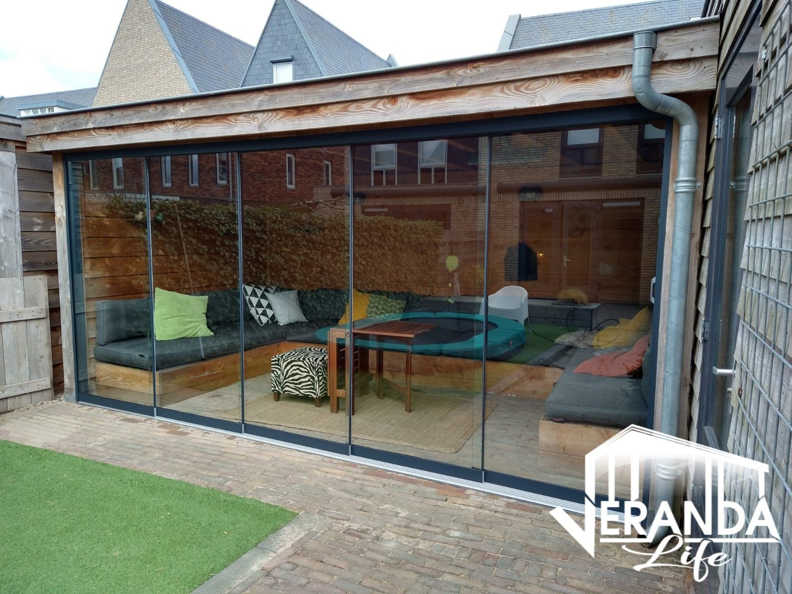 Een woonkamer met glazen schuifdeuren en een bank.