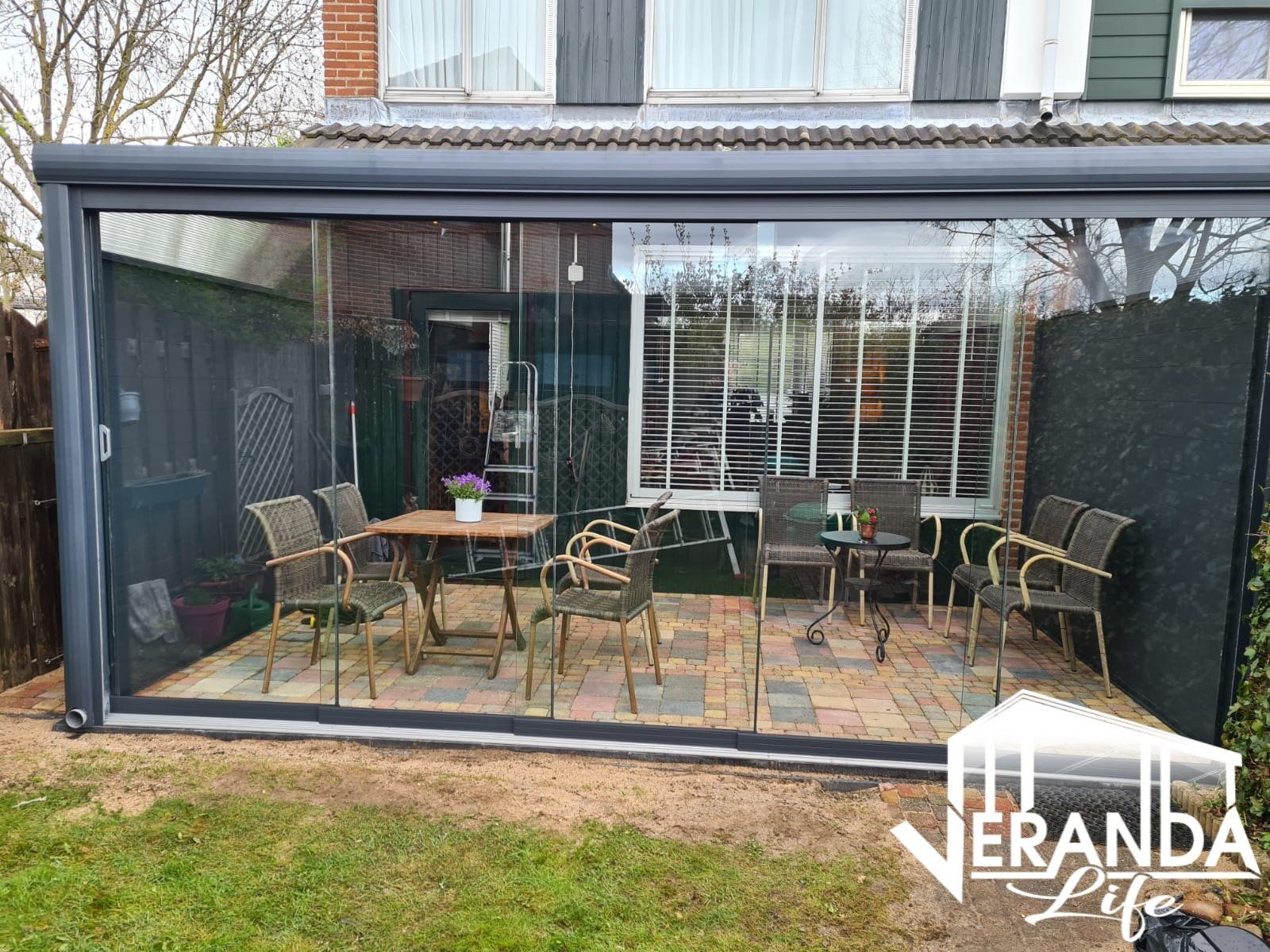 Een patio met een tafel en stoelen voor een huis.