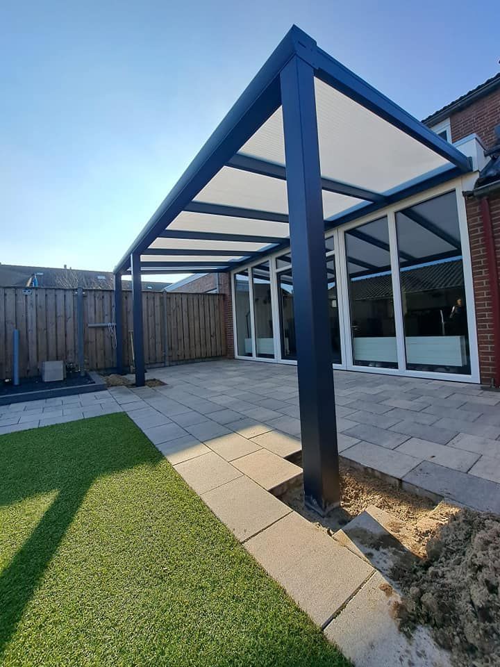 In de achtertuin van een huis bevindt zich een terras met een overkapping.