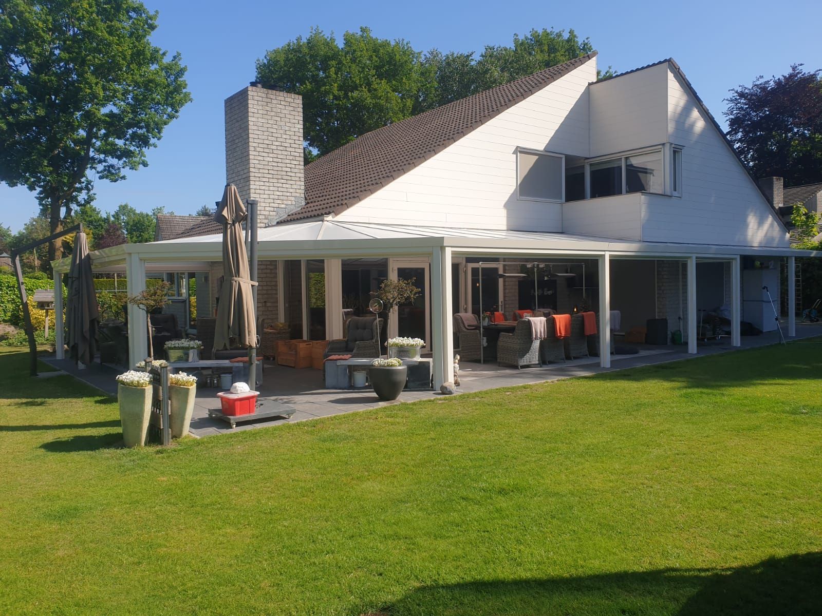 Een groot wit huis met een groot grasveld ervoor