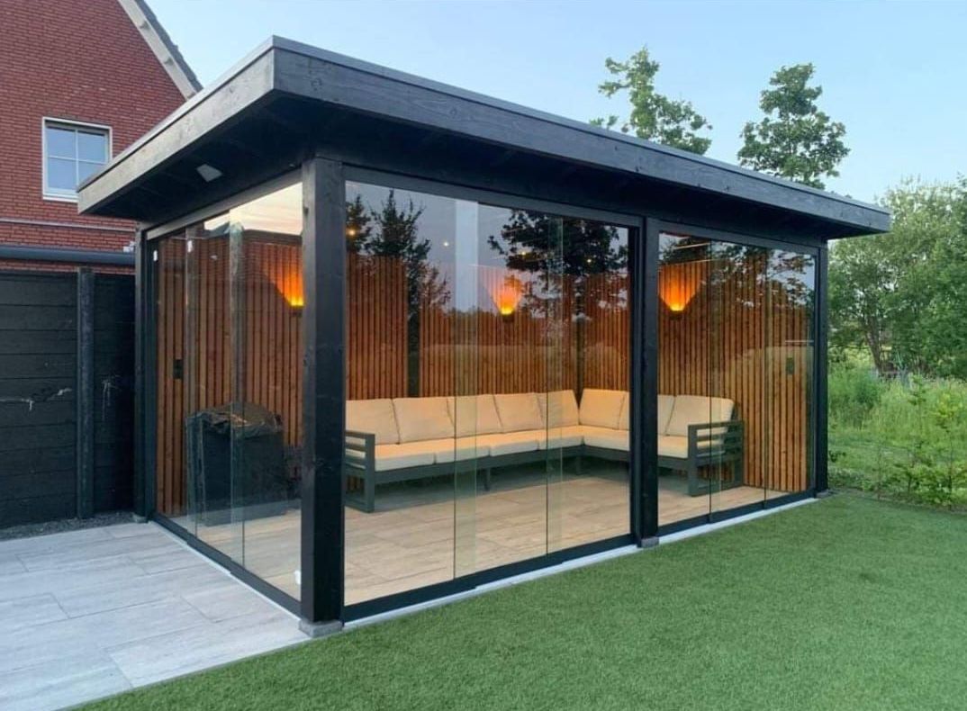 Een tuinhuisje met daarin een bank en stoelen.