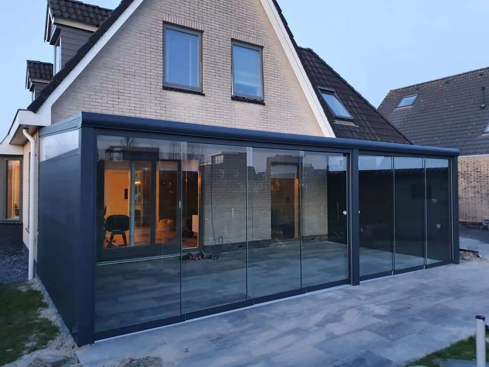 Een huis met een grote glazen schuifdeur aan de zijkant.