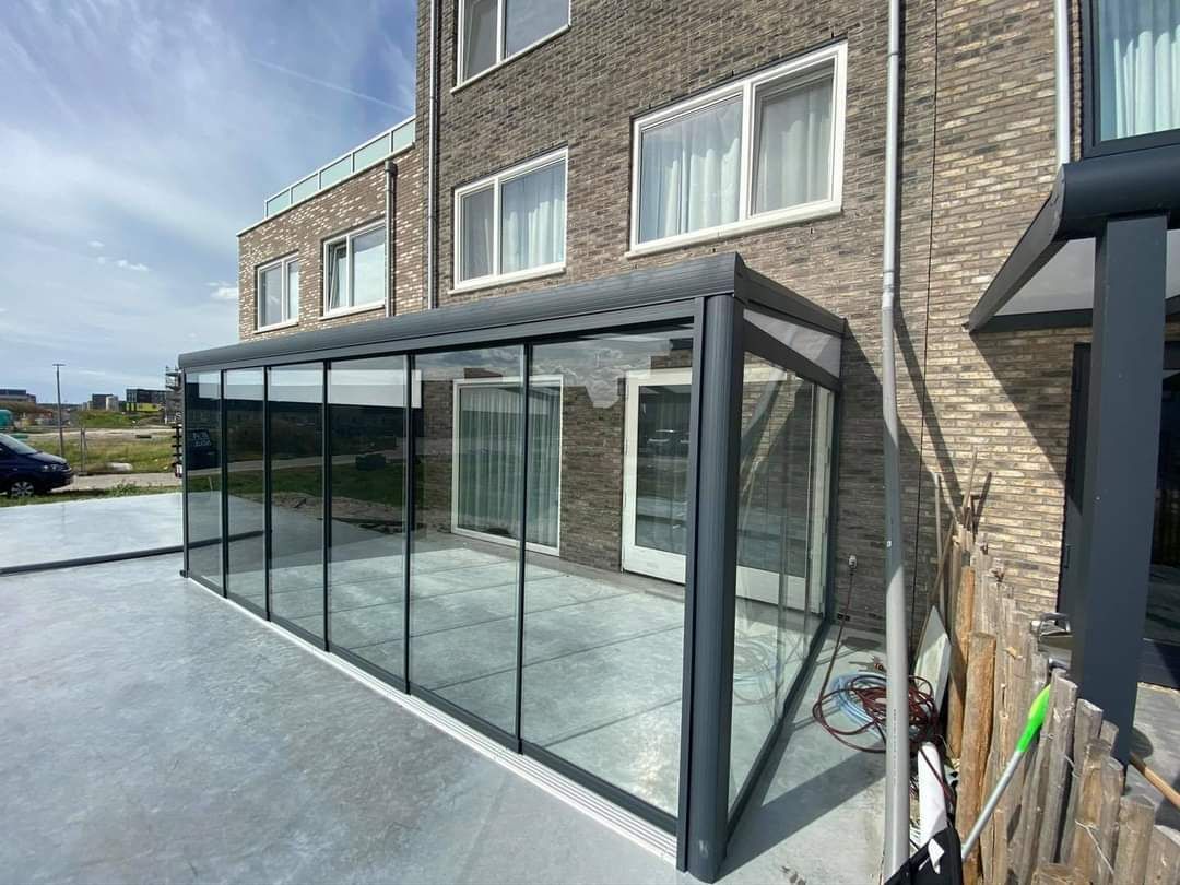 Een groot gebouw met een grote glazen kamer ervoor.