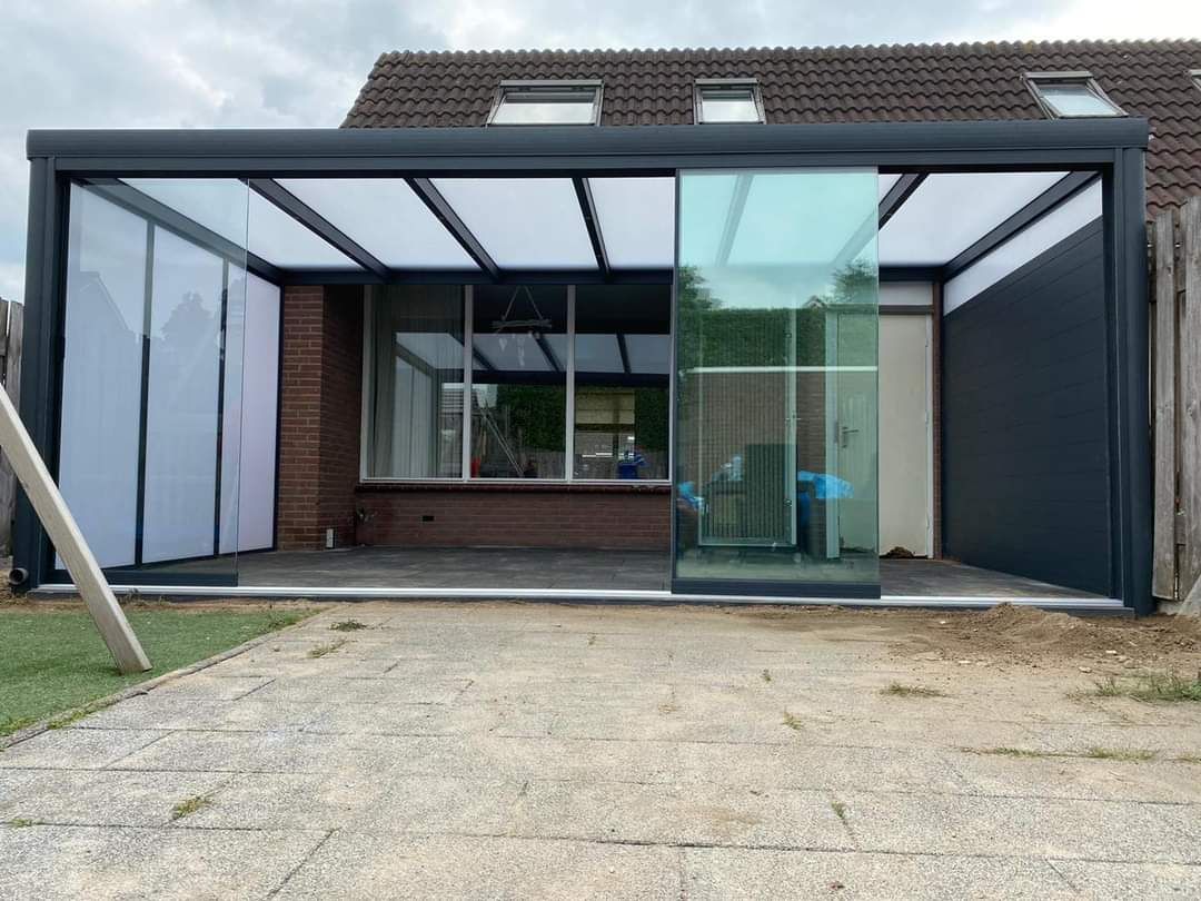 Een huis met een glazen schuifdeur die op een kas lijkt.