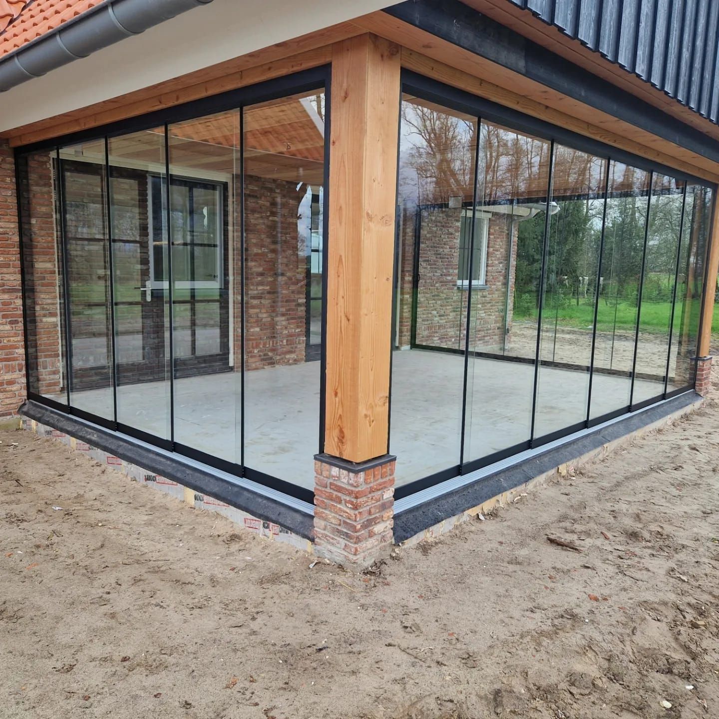 Een huis met veel ramen en een bakstenen muur