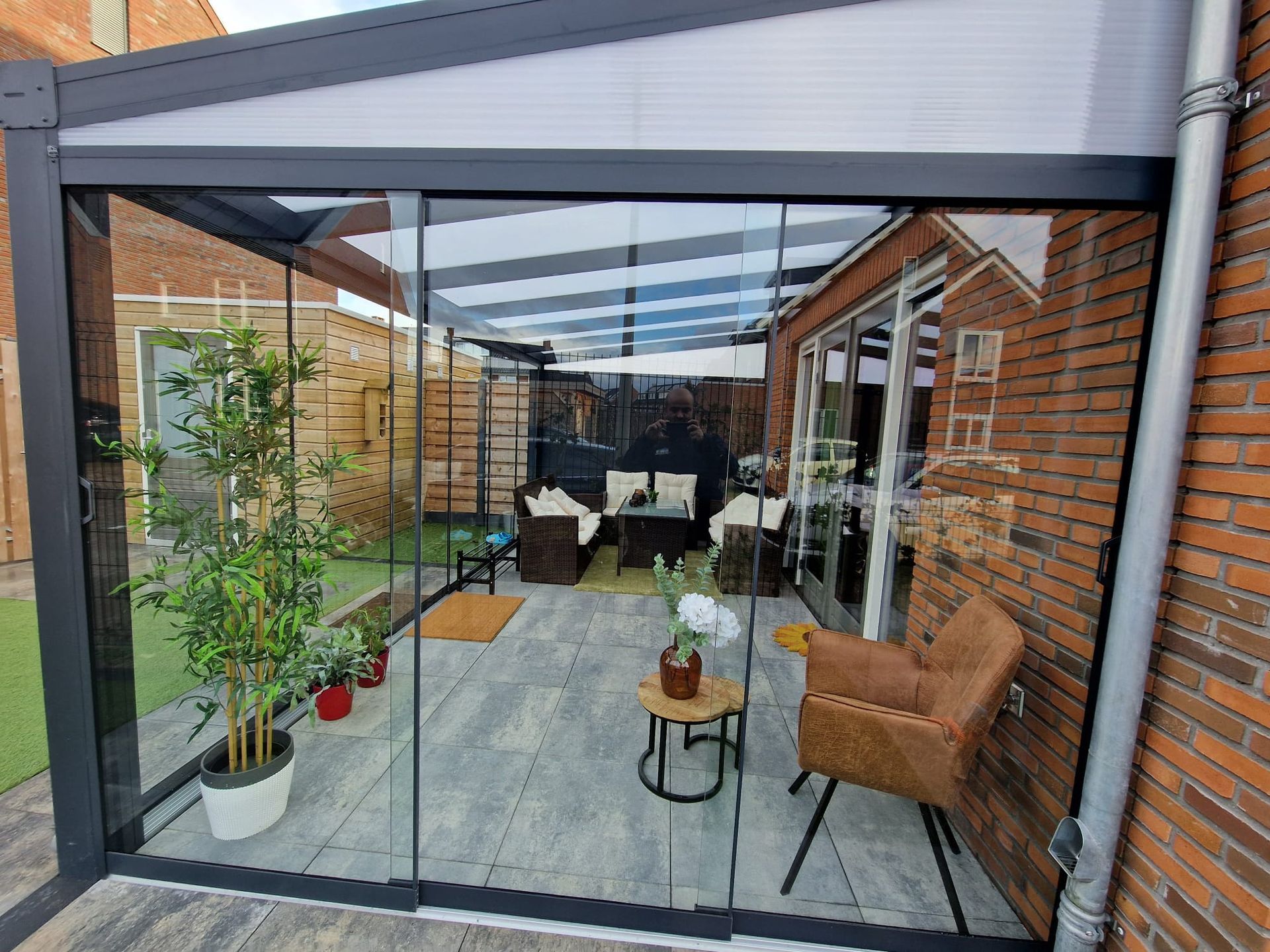 Een patio met glazen schuifdeuren en een overkapping.