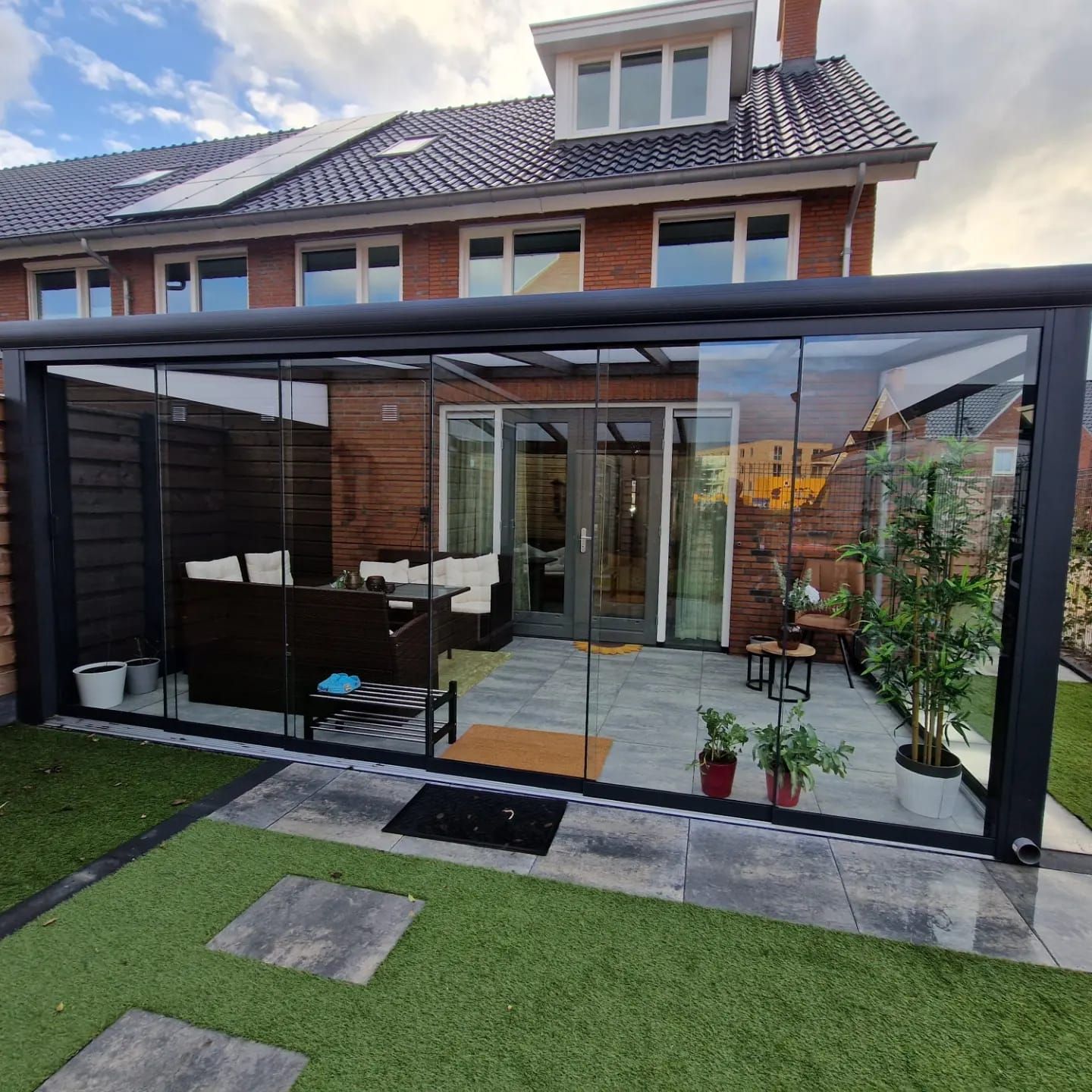 Een huis met een patio met een glazen schuifdeur