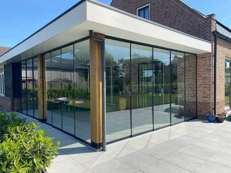 Een huis met veel ramen en een patio ervoor.