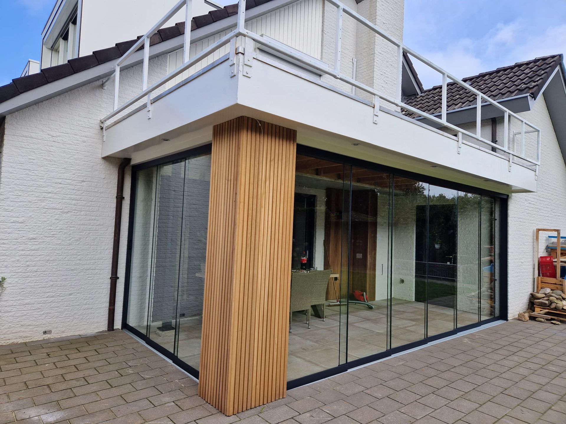 Een huis met een balkon en glazen schuifdeuren