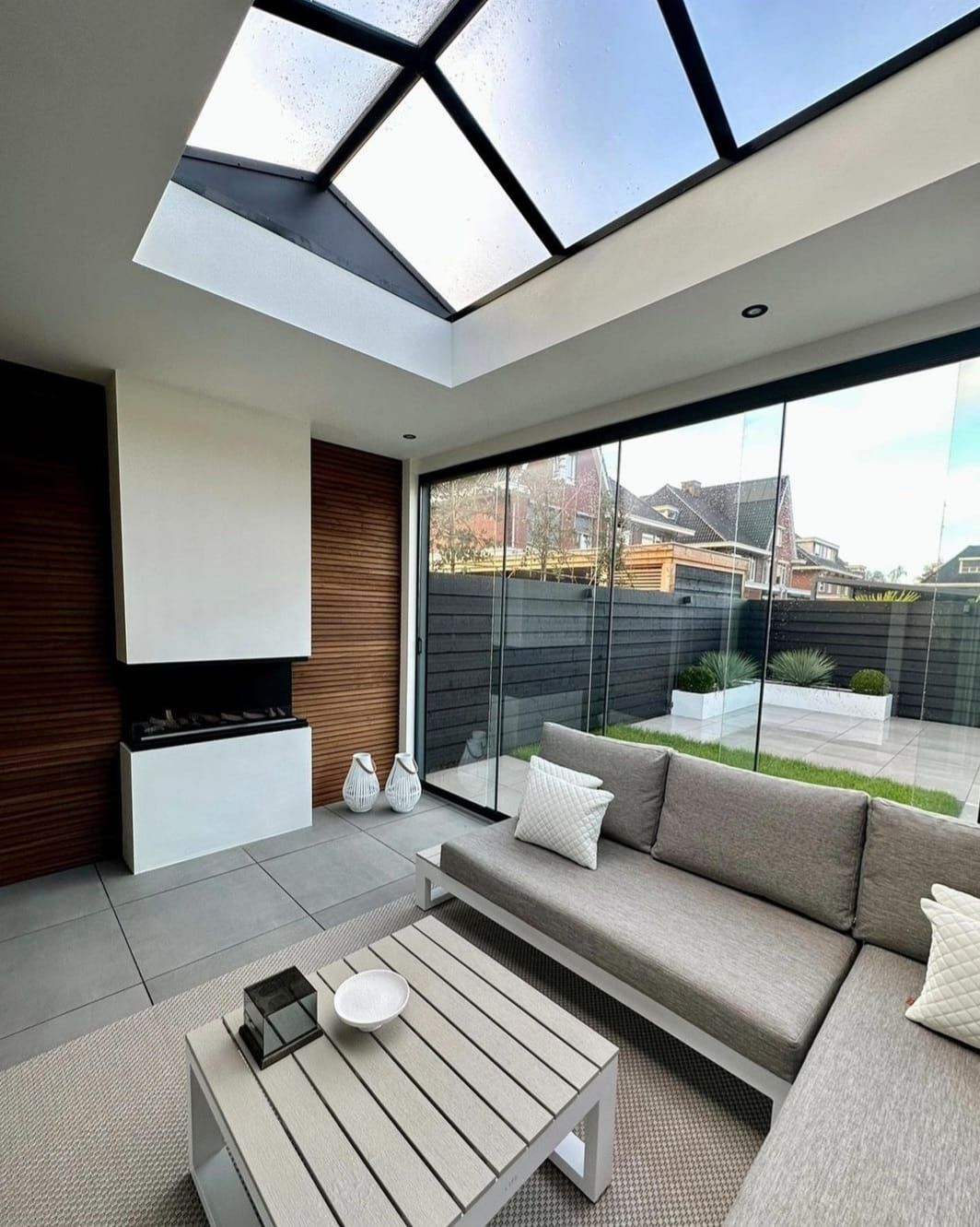 Een woonkamer met een bank, tafel en dakraam.