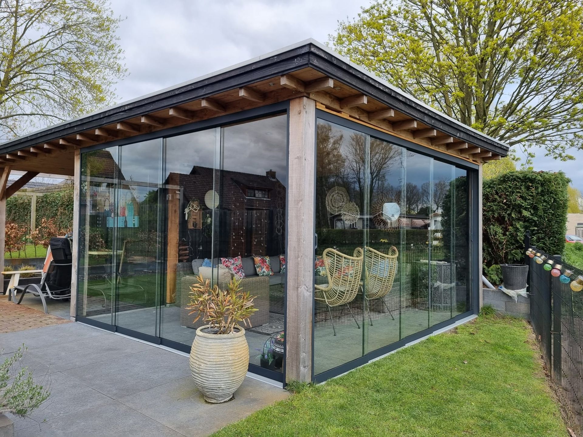 Een huis met veel ramen en een potplant ervoor.