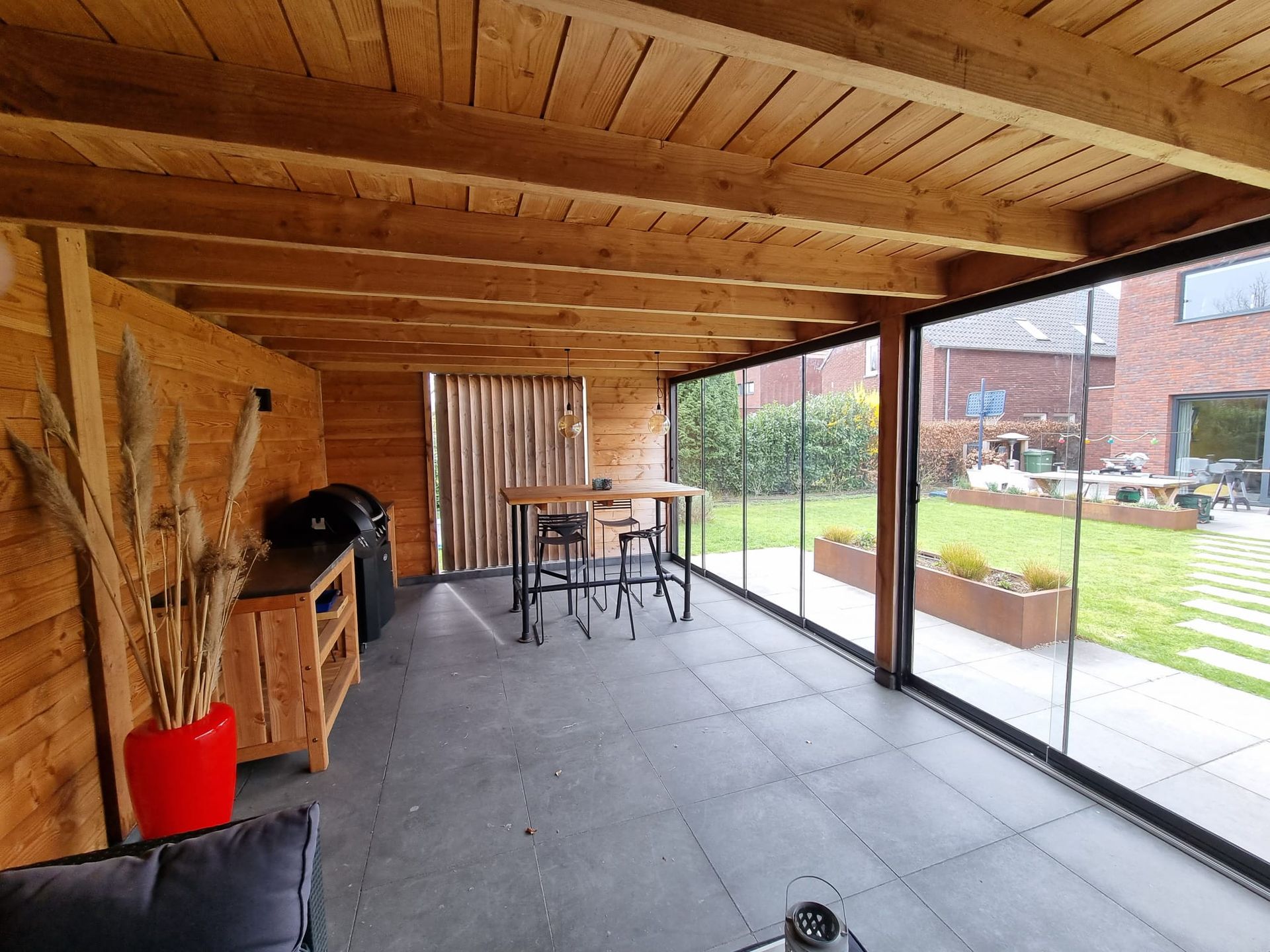 Er is een tafel en stoelen in de kamer met glazen schuifdeuren.