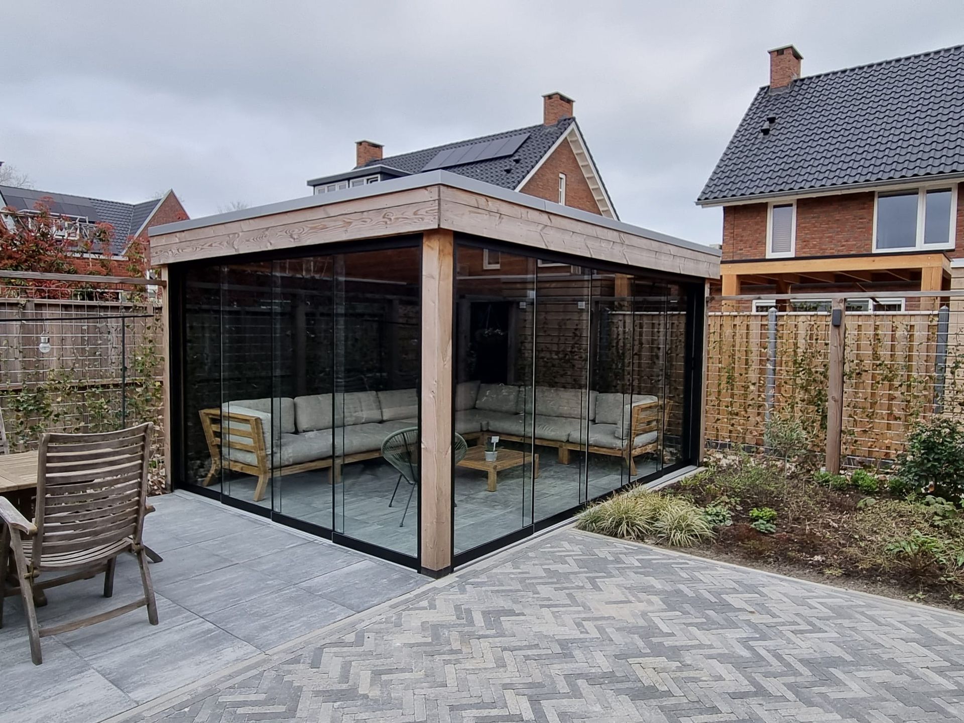 Een patio met een bank, tafel, stoelen en glazen schuifdeuren.