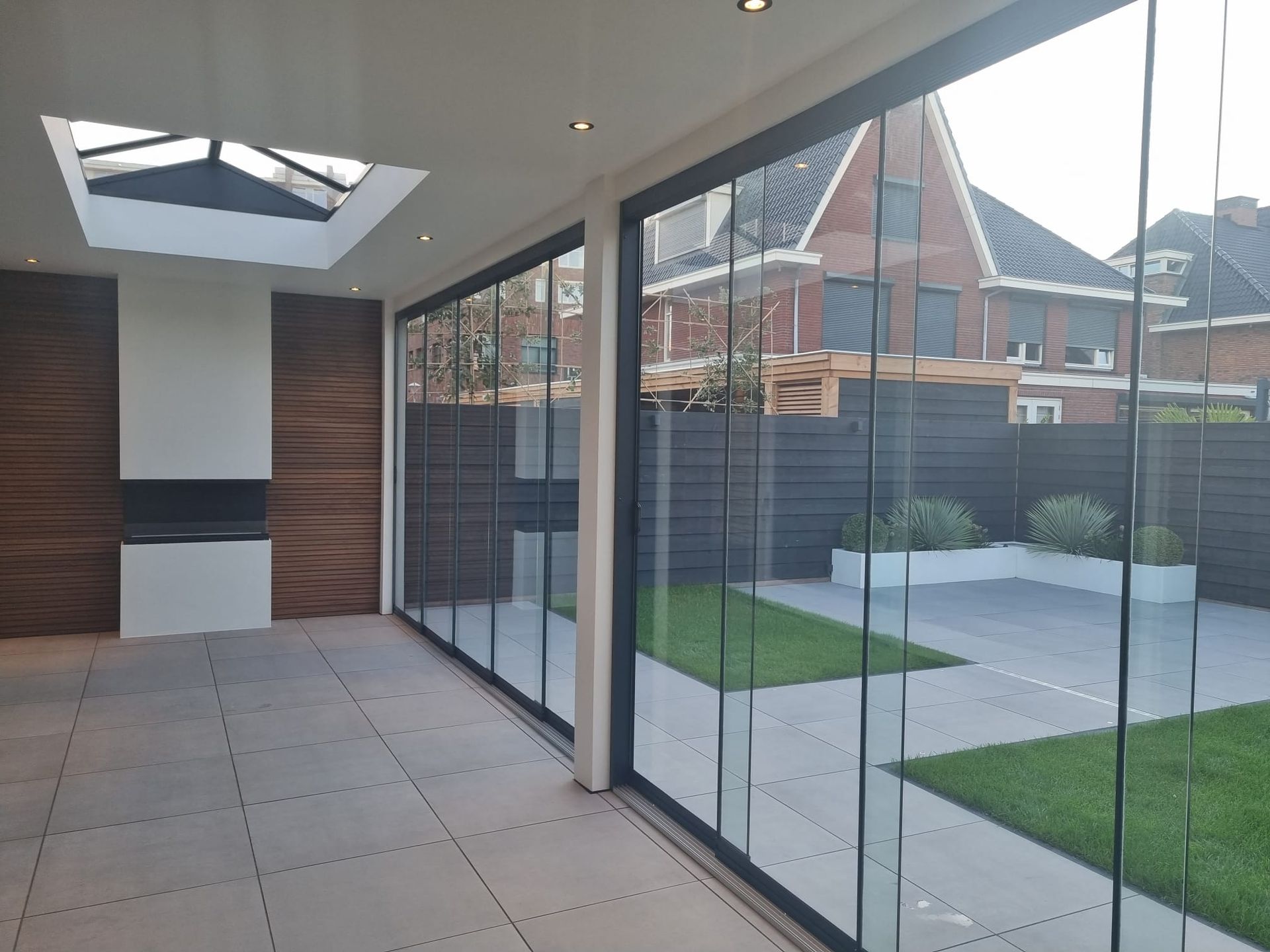 Een lege kamer met glazen schuifdeuren die naar een achtertuin leiden