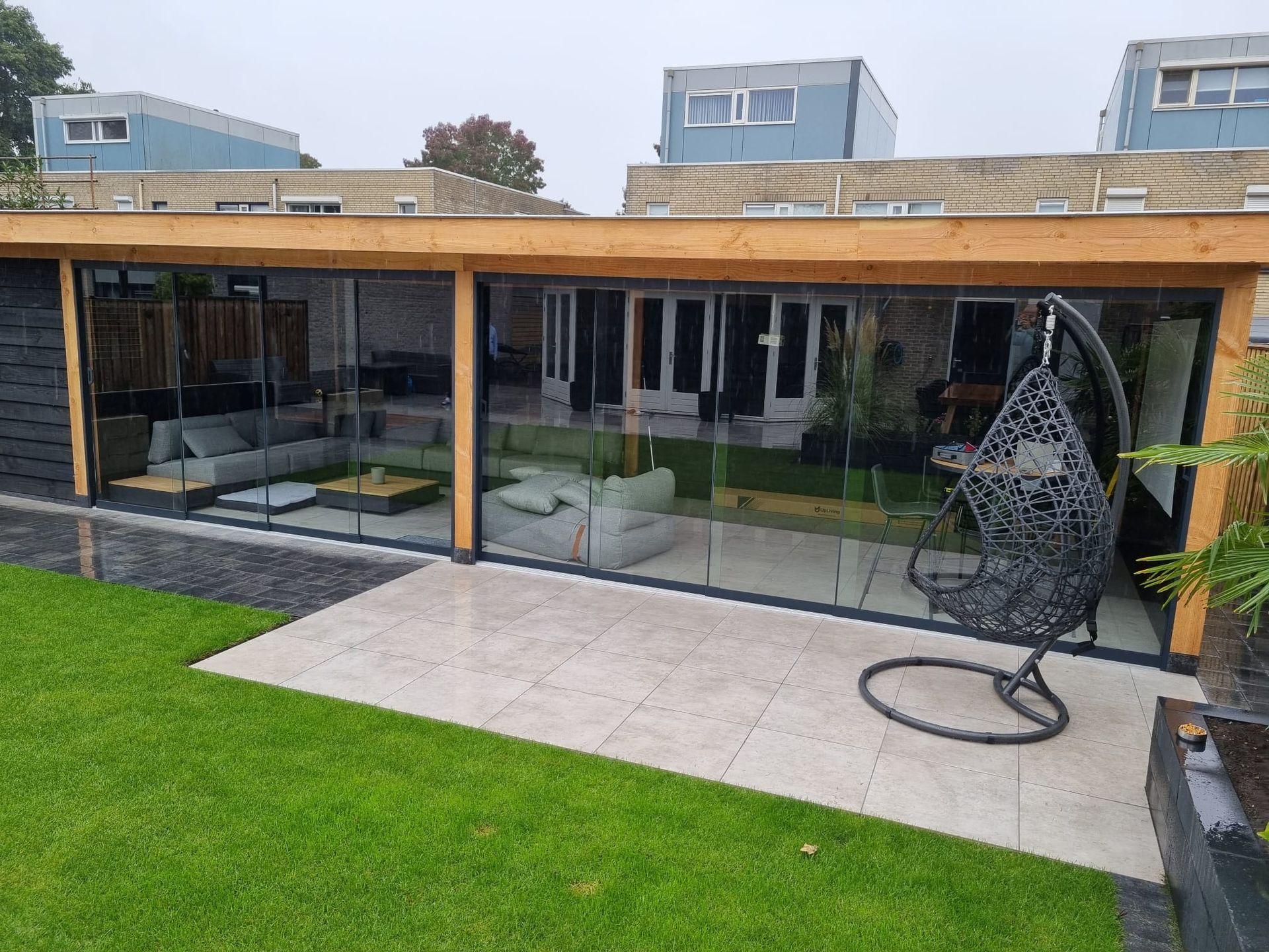 Een groot huis met een hangstoel ervoor.