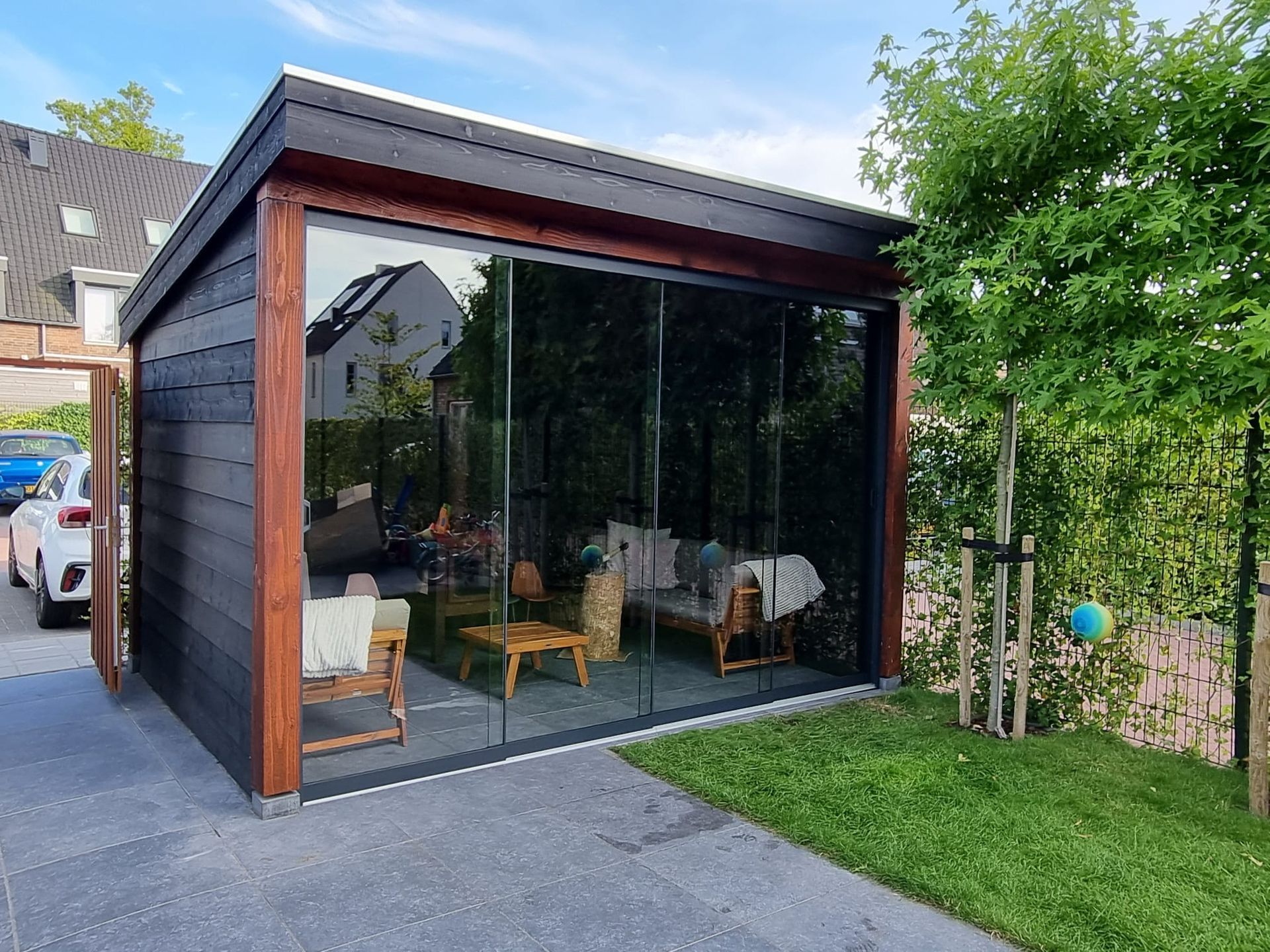 Een huis met veel ramen en een auto ervoor geparkeerd