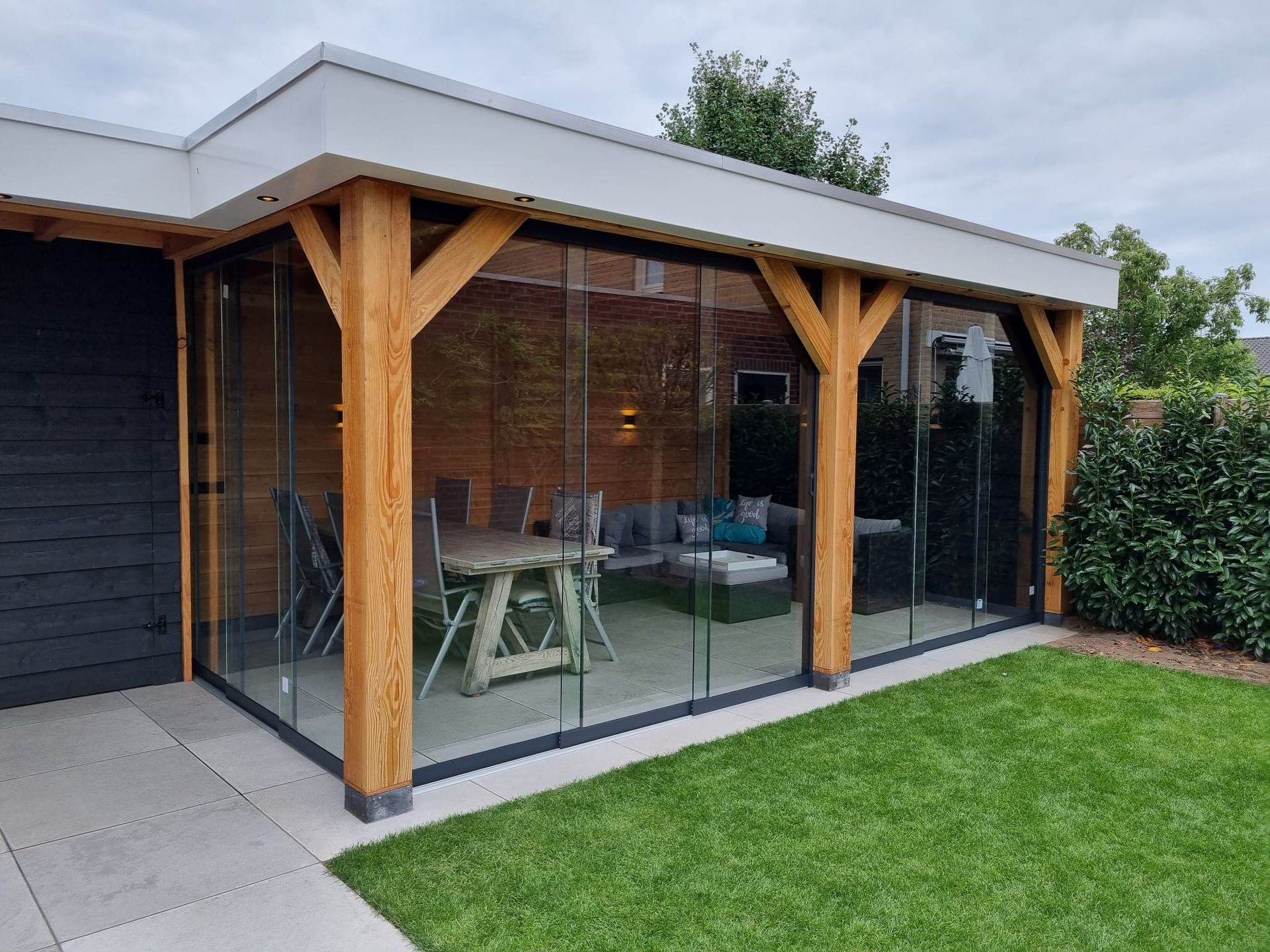 Een patio met glazen schuifdeuren en een tafel en stoelen.
