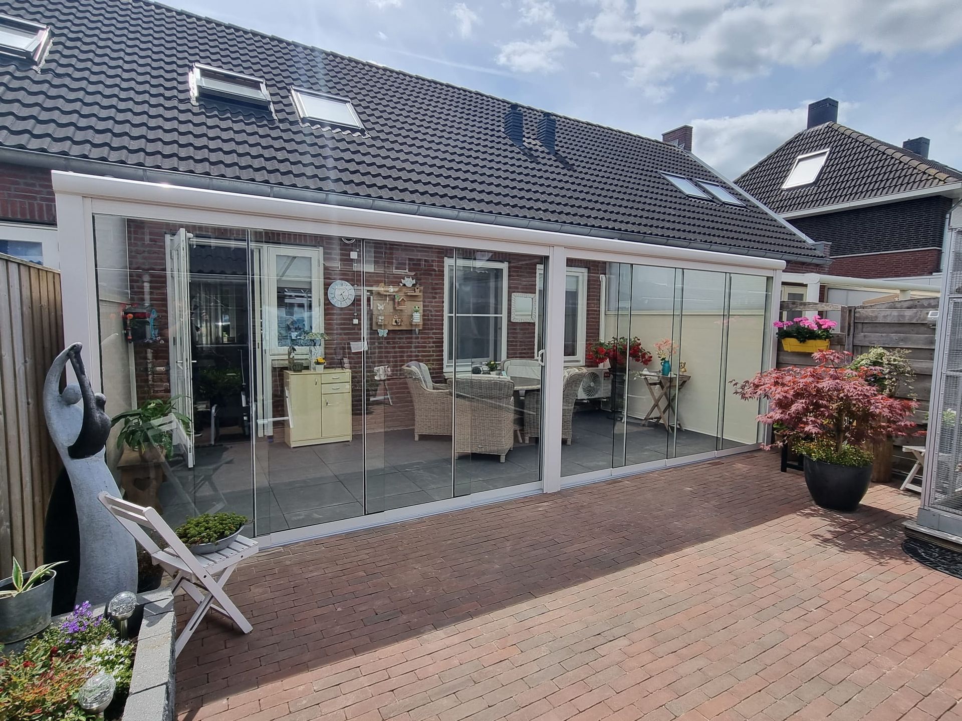 Een patio met glazen schuifdeur voor een huis.